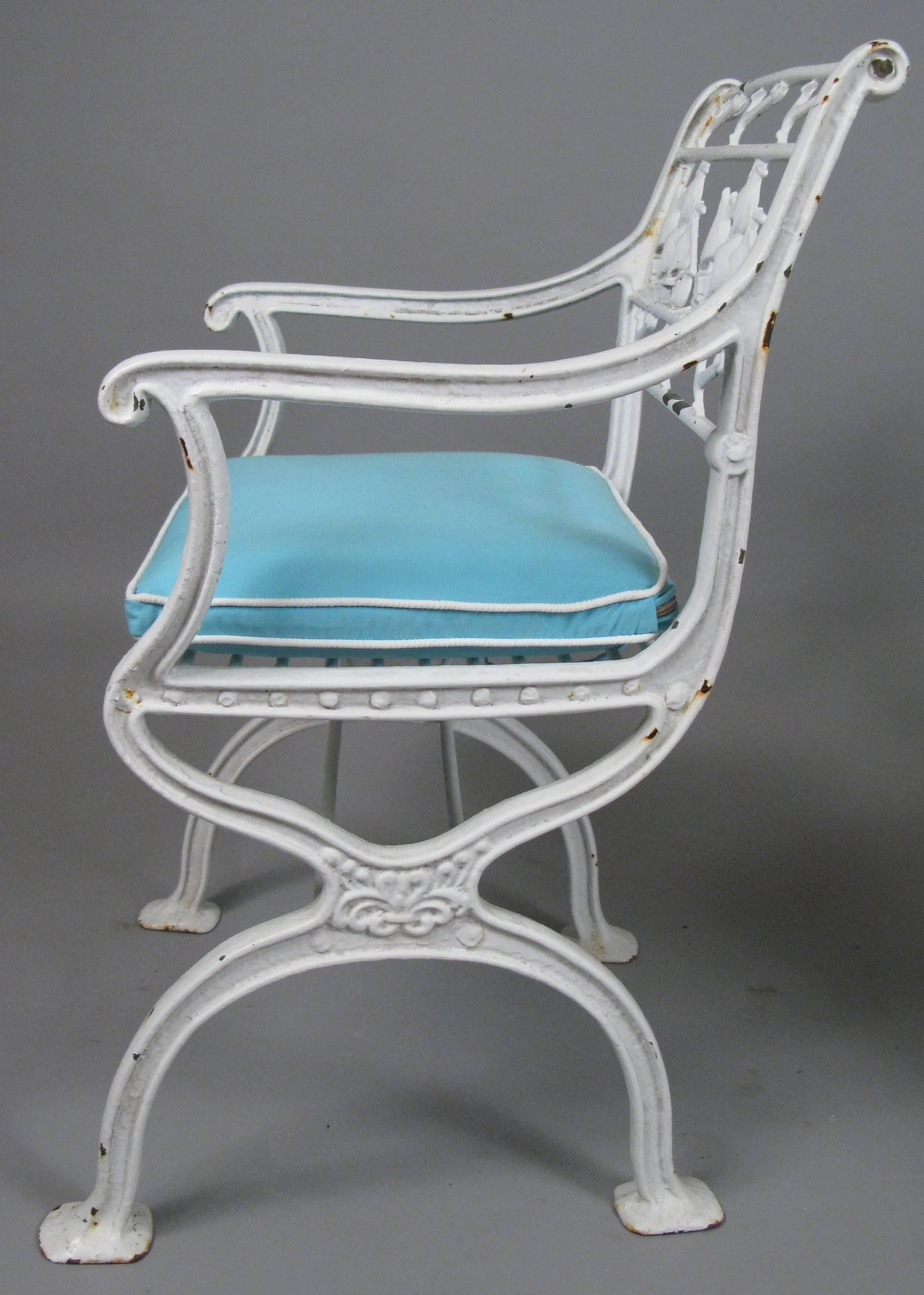 A rare pair of antique early 20th century cast iron garden chairs in the style of Schinkel, with a frieze featuring sailing ships and anchors in the seatback. Beautiful design and very heavy and well made. with new seat cushions in pale blue with