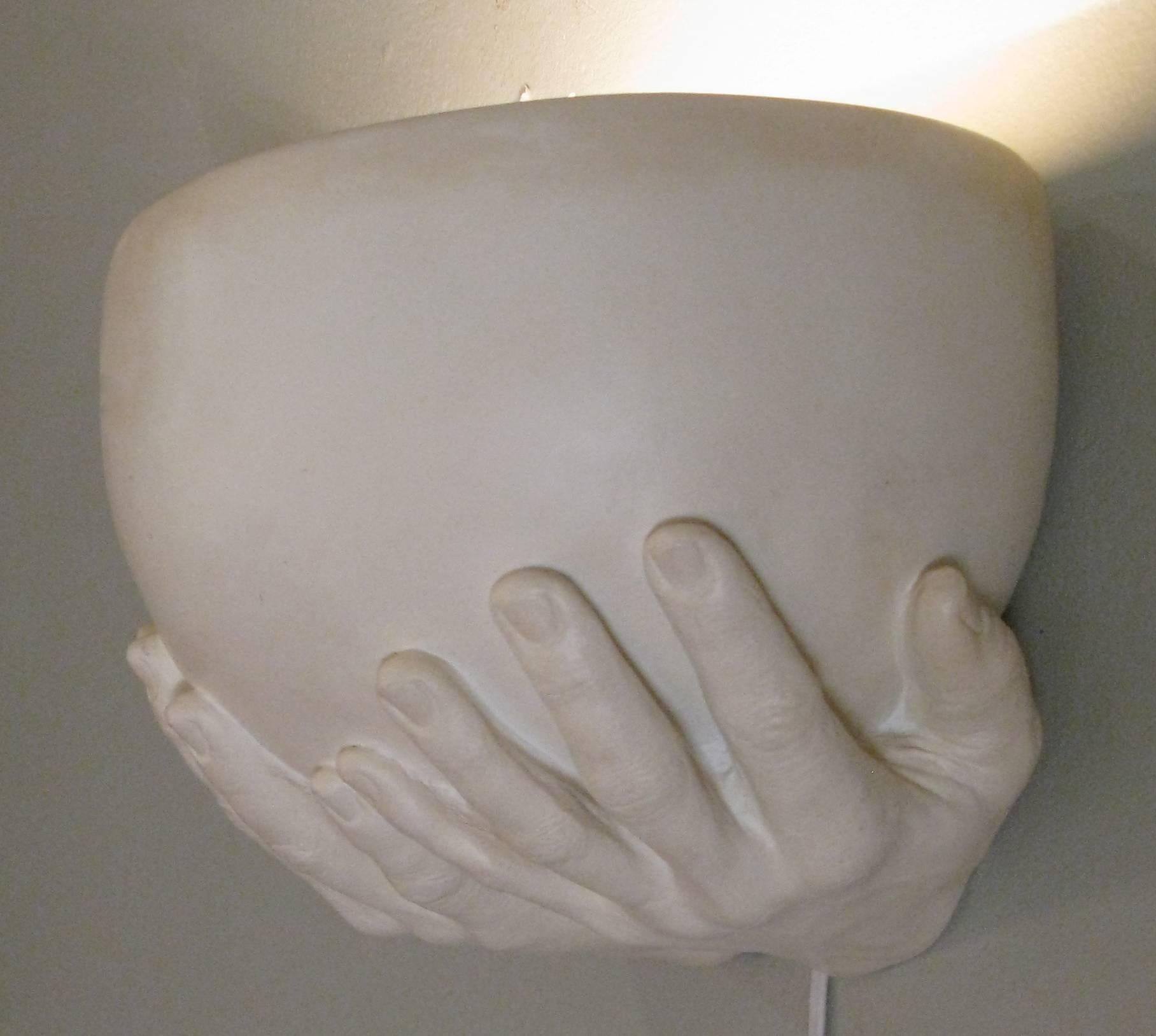 A beautiful plaster lighted wall sconce made by artist Richard Etts, from his iconic 'Hands' series. Crafted with a pair hands holding a half bowl with a single light socket. Signed and dated 'Richard Etts 1976'.
 