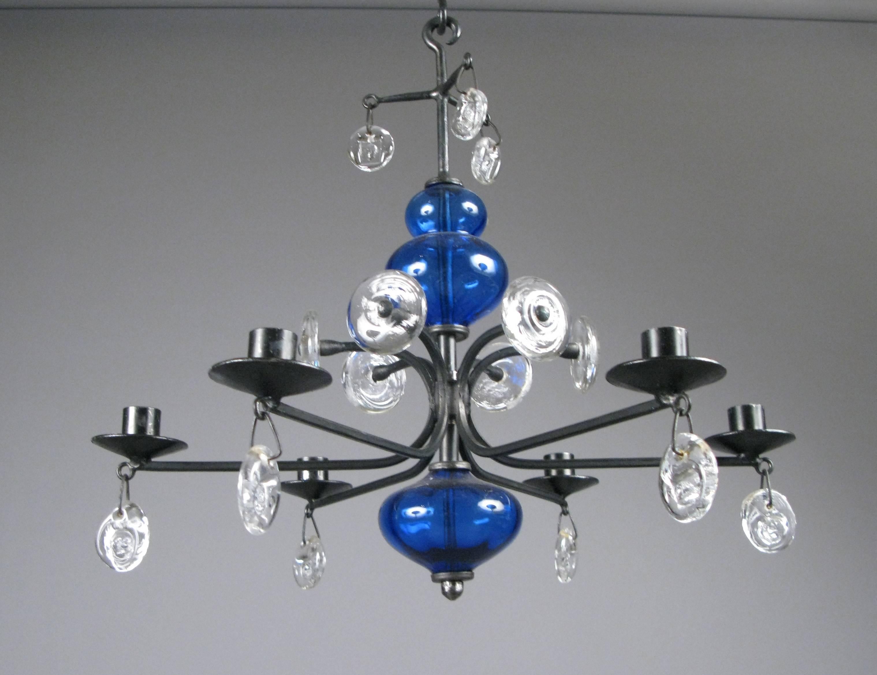 A beautiful iconic 1960s chandelier designed by Erik Hoglund for Kosta Boda, with cobalt blue and white blown glass, and wrought iron frame. With six candle holders, in excellent original condition.