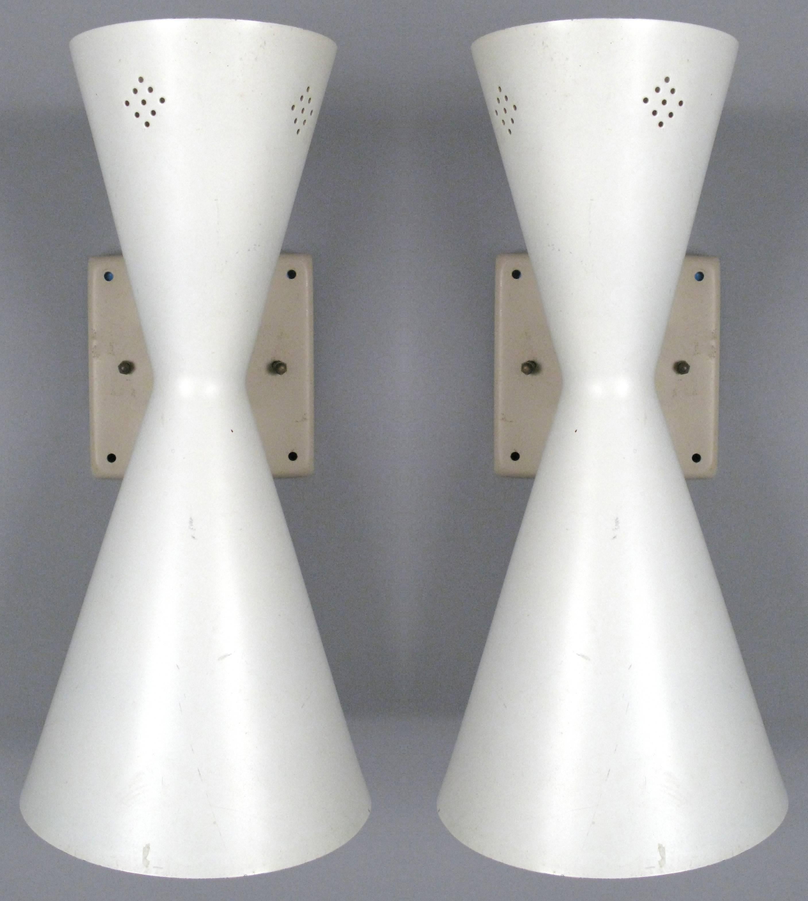 a pair of classic 1950's mid century wall sconces with double cone design. each sconce has a larger down facing cone, and a smaller uplight cone, each one with a socket. so there are a total of four sockets in the pair of sconces. the uplight is
