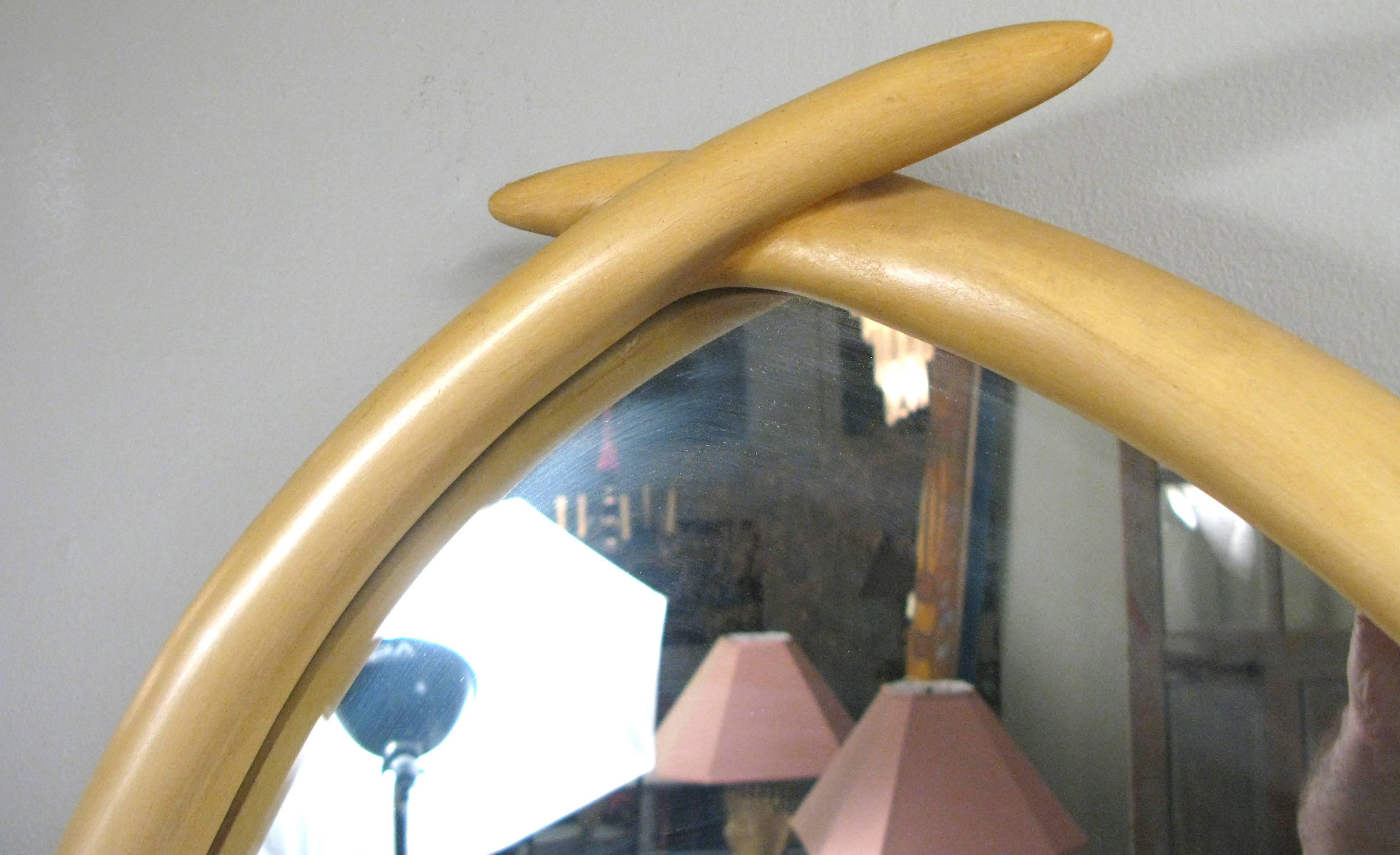 Wonderful vintage 1970s mirror by Chapman in the form of crossed elephant tusks with patinated brass bands on the sides. Great form and character.