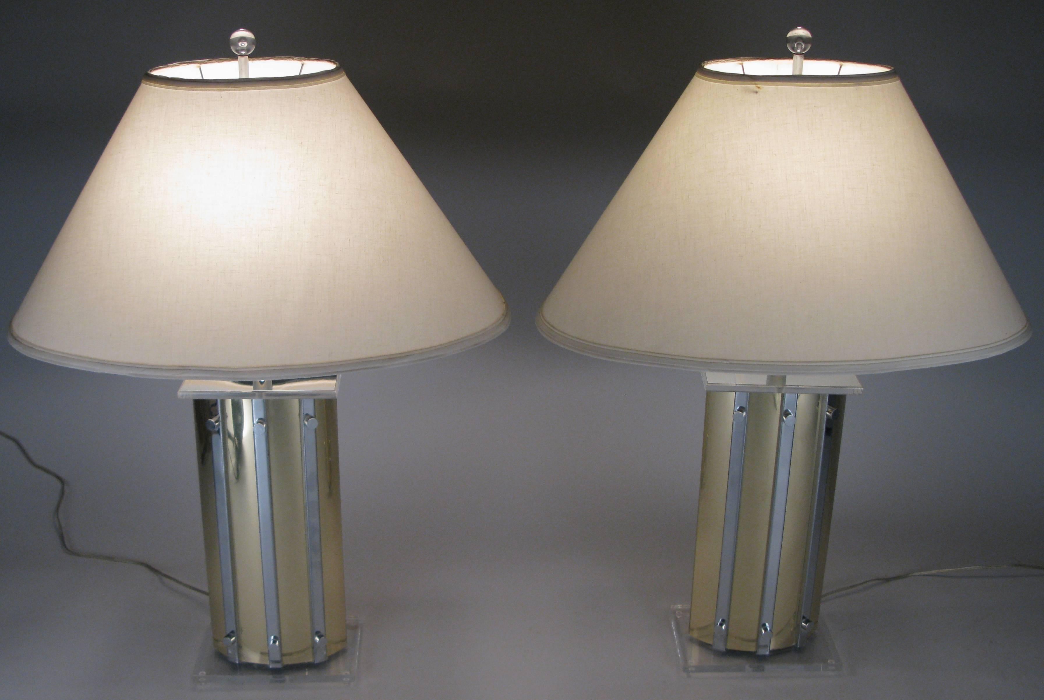 A very stylish pair of vintage 1970s oval table lamps in brass with chrome accent panels, and Lucite bases. Great design in excellent condition with their original oval shades.
