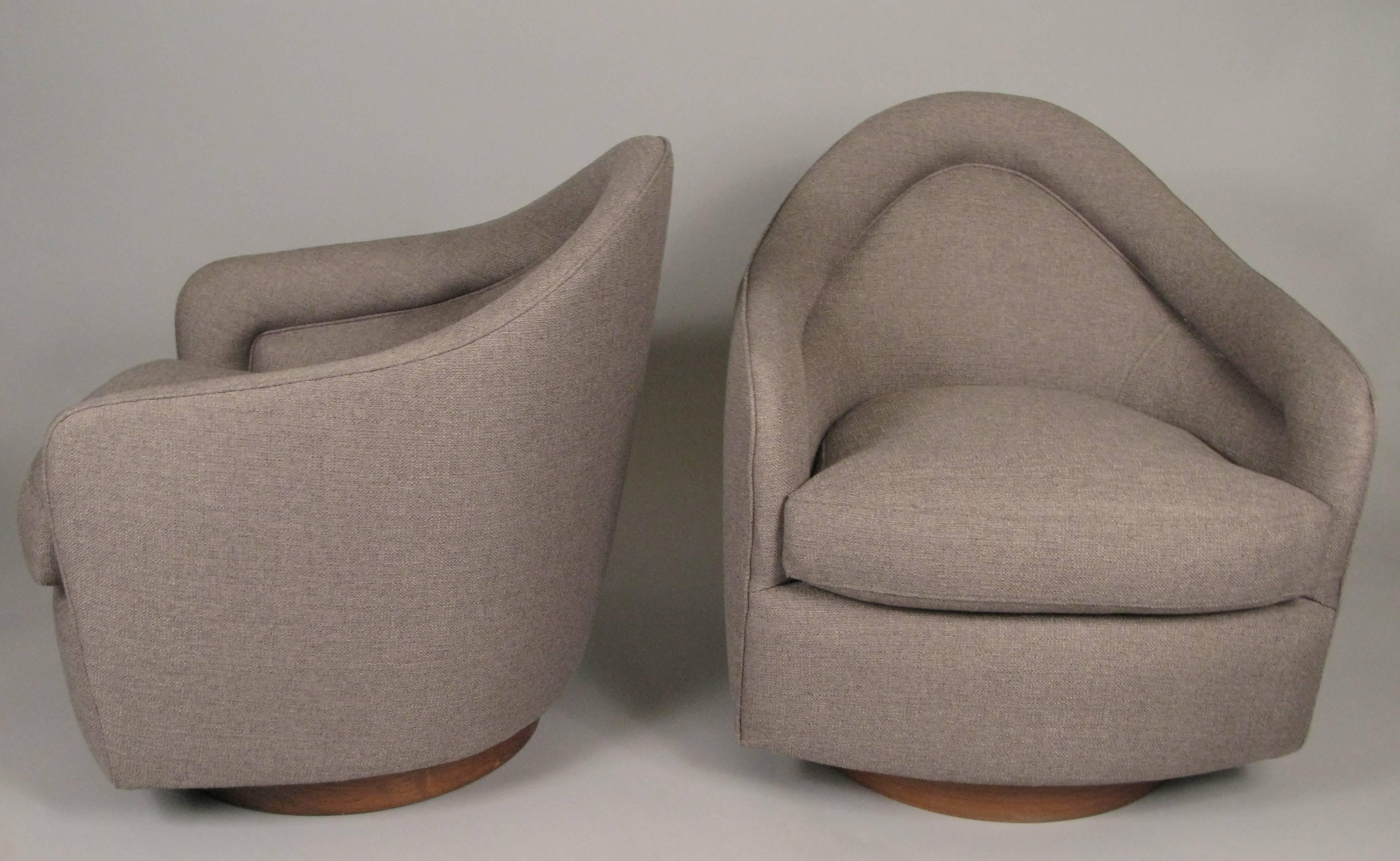 One of the most comfortable modern lounge chairs from the 1960s, this swivel and tilt lounge chair designed by Milo Baughman for Thayer Coggin is a Classic. The pair is raised on walnut round bases, and the chairs have been reupholstered beautifully