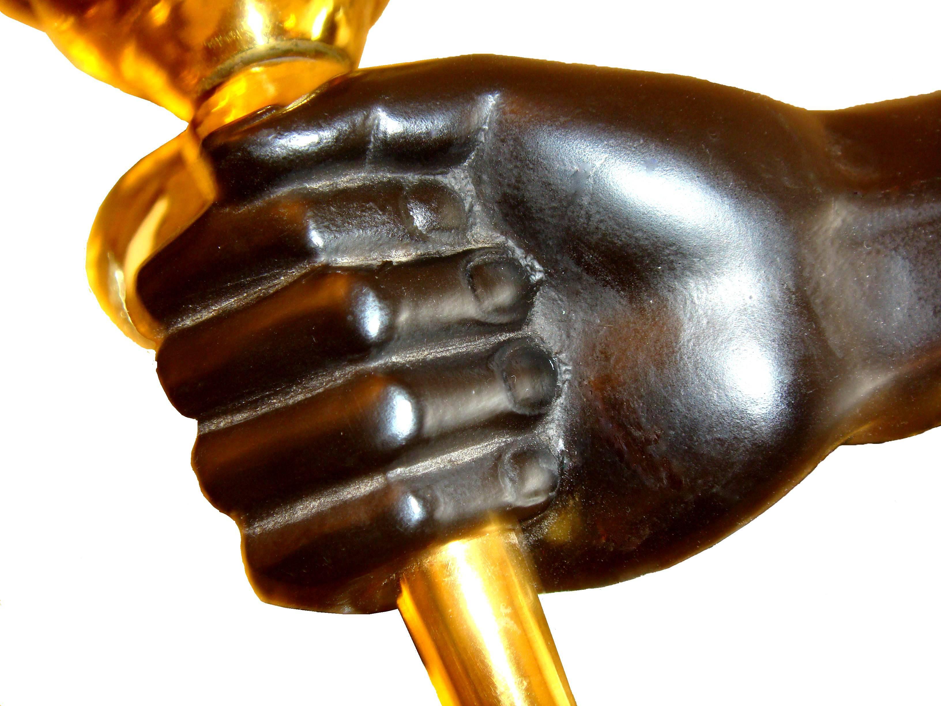 Pair of Bronze Andre Arbus wall sconces depicting hands holding torchieres;
 Black and gold paper shades.
2 pairs available. Priced by pair.
brass and bronze
60W per bulb
wired to US standard in working condition
original antique patina.