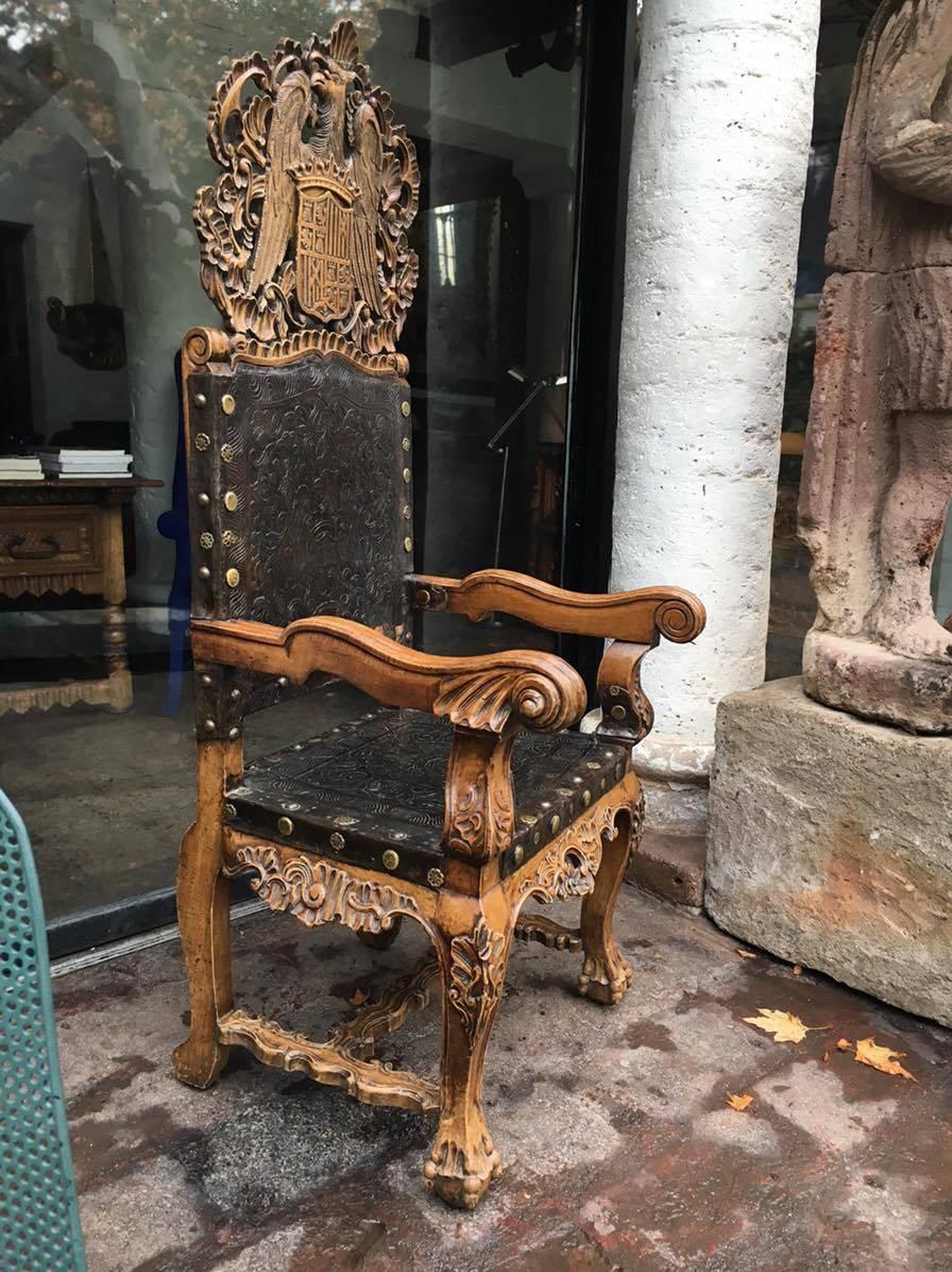 Overscale Peruvian chair with adorning eagle crown known traditionally as a Frailero (Fryer's Chair) was handcrafted in Trujillo with detailed carved aliso (high altitude water cypress) wood along with hand tooled leather stretched across to form