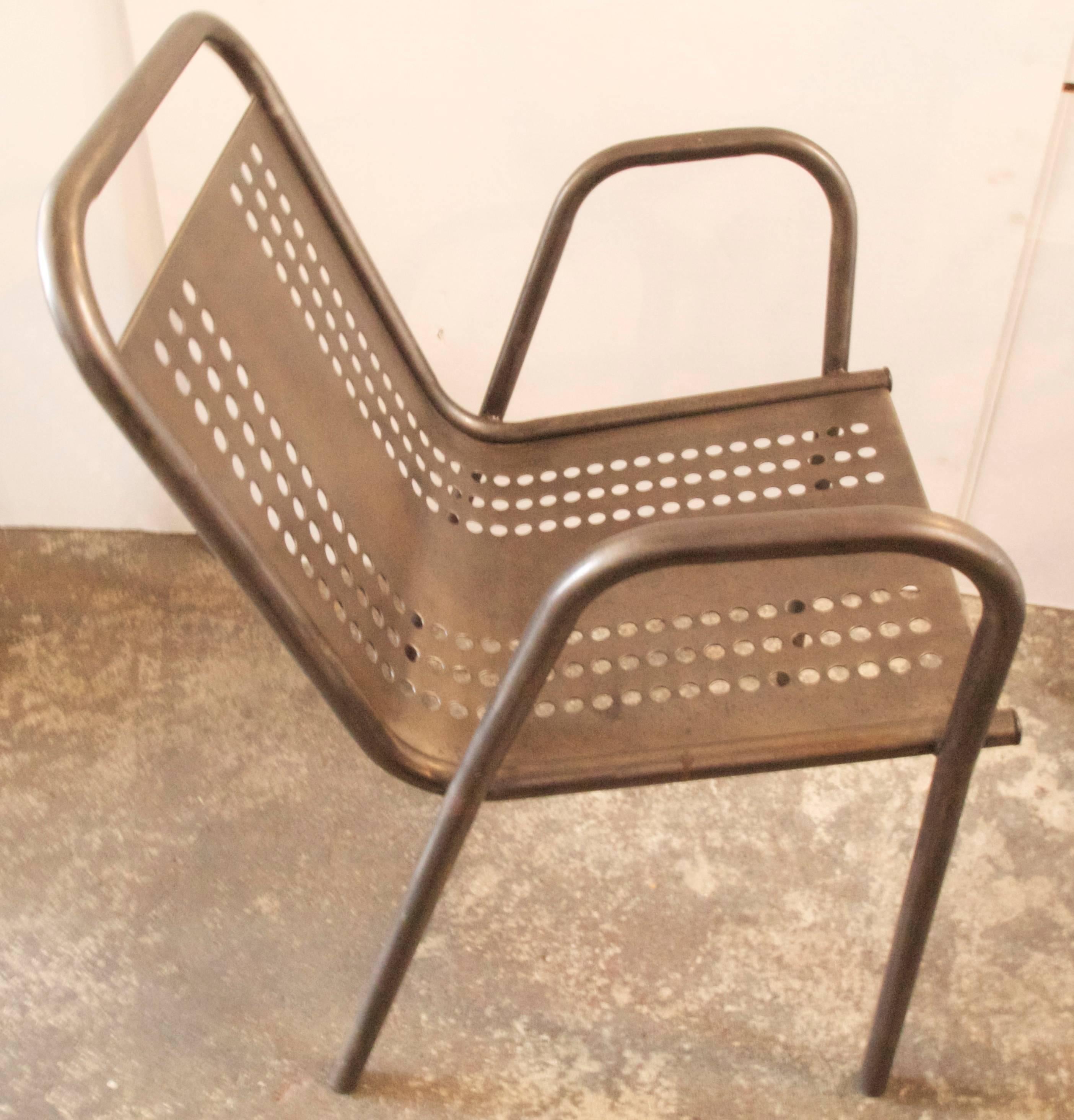 Wonderful pair of French industrial Mid-Century perforated steel and tube steel stacking lounge armchairs with nice patina.