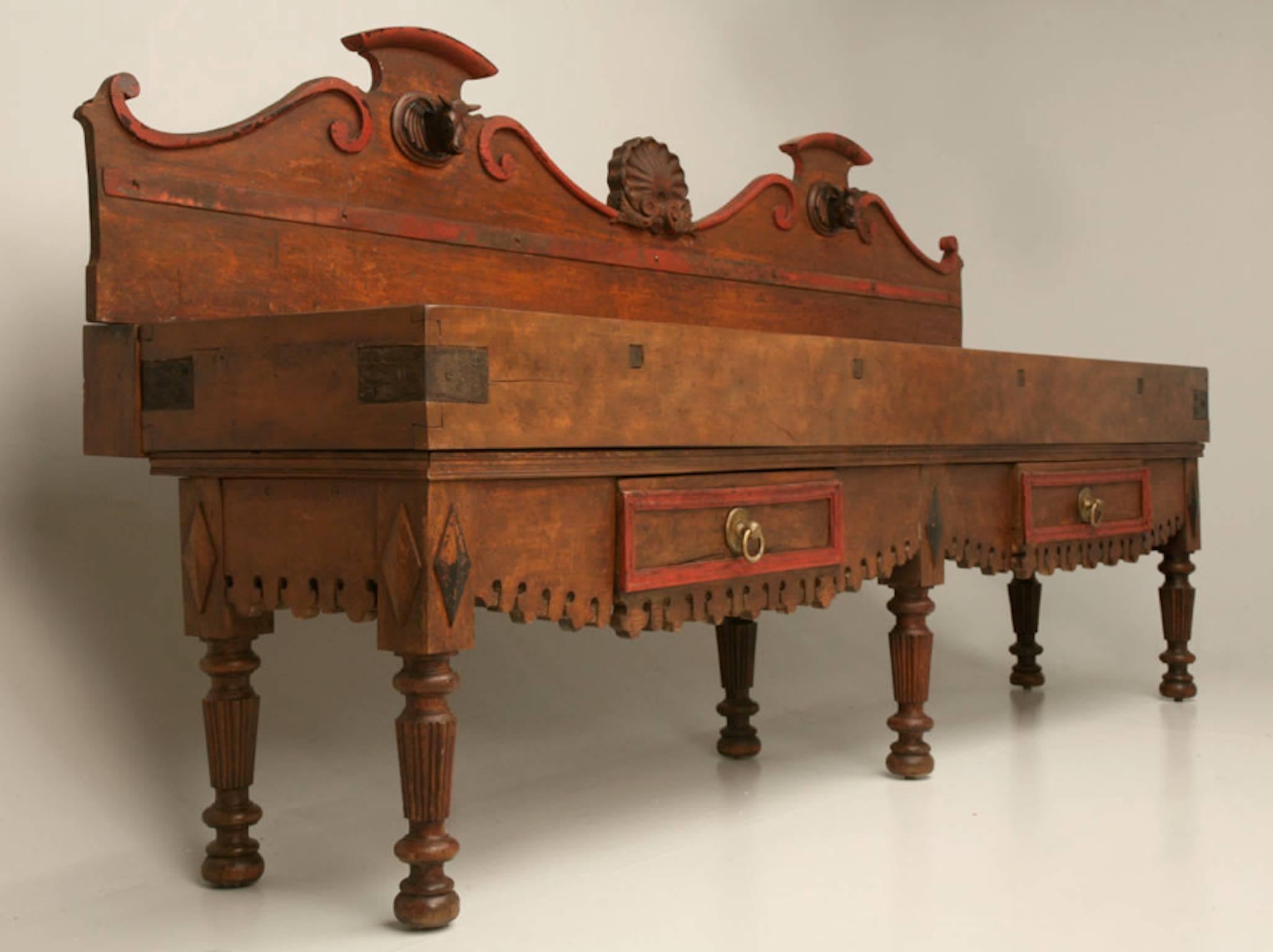 Rare and unique massive French double butcher block, circa 1890 - retaining its original red paint, with two drawers and knife holders, elaborately carved legs, apron and shaped backboard with a centered shell and two steer heads.
Provenance: