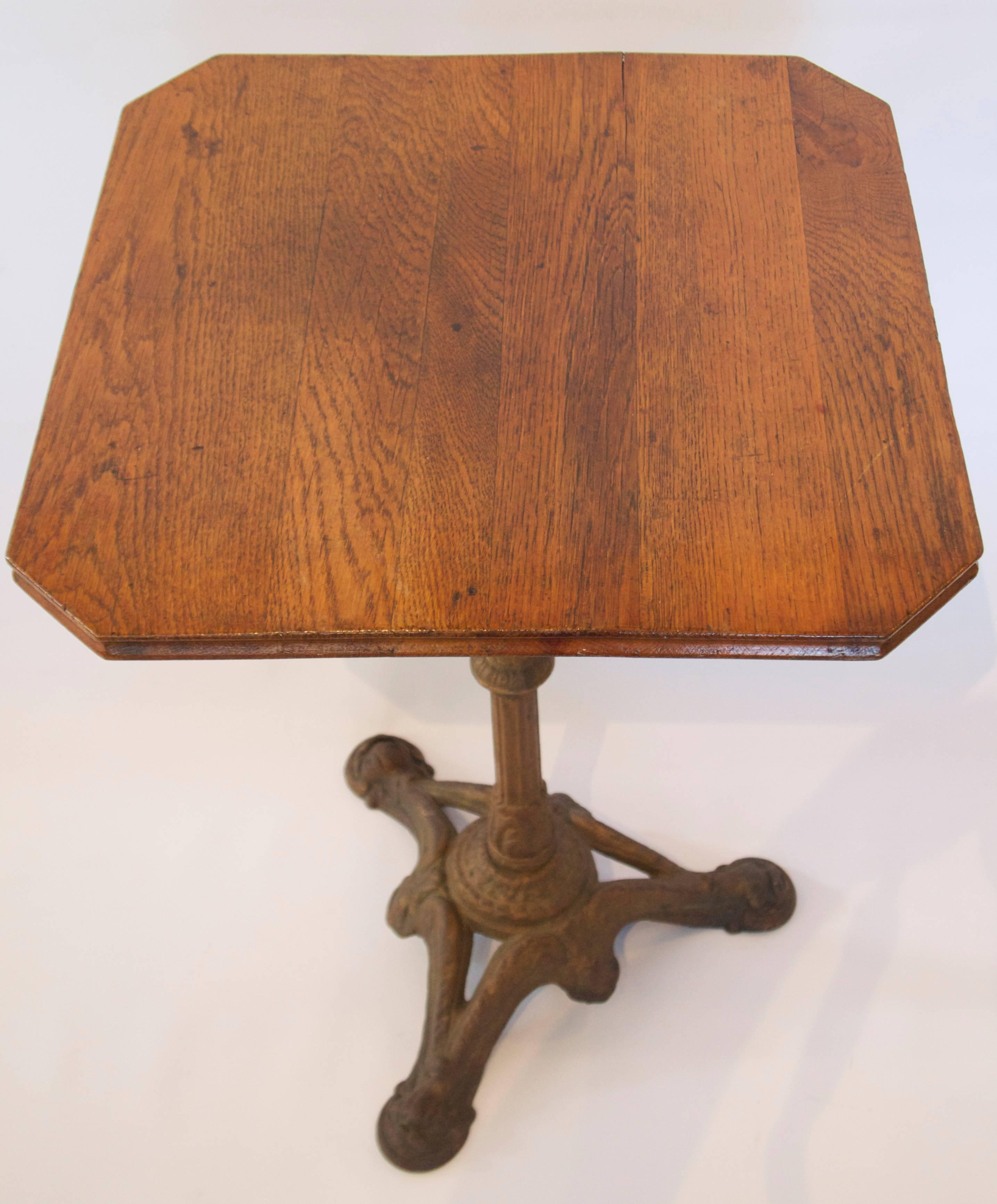 Square oak top bistro table of small size on a painted cast iron tripod pedestal base.
Early 20th century,
France.