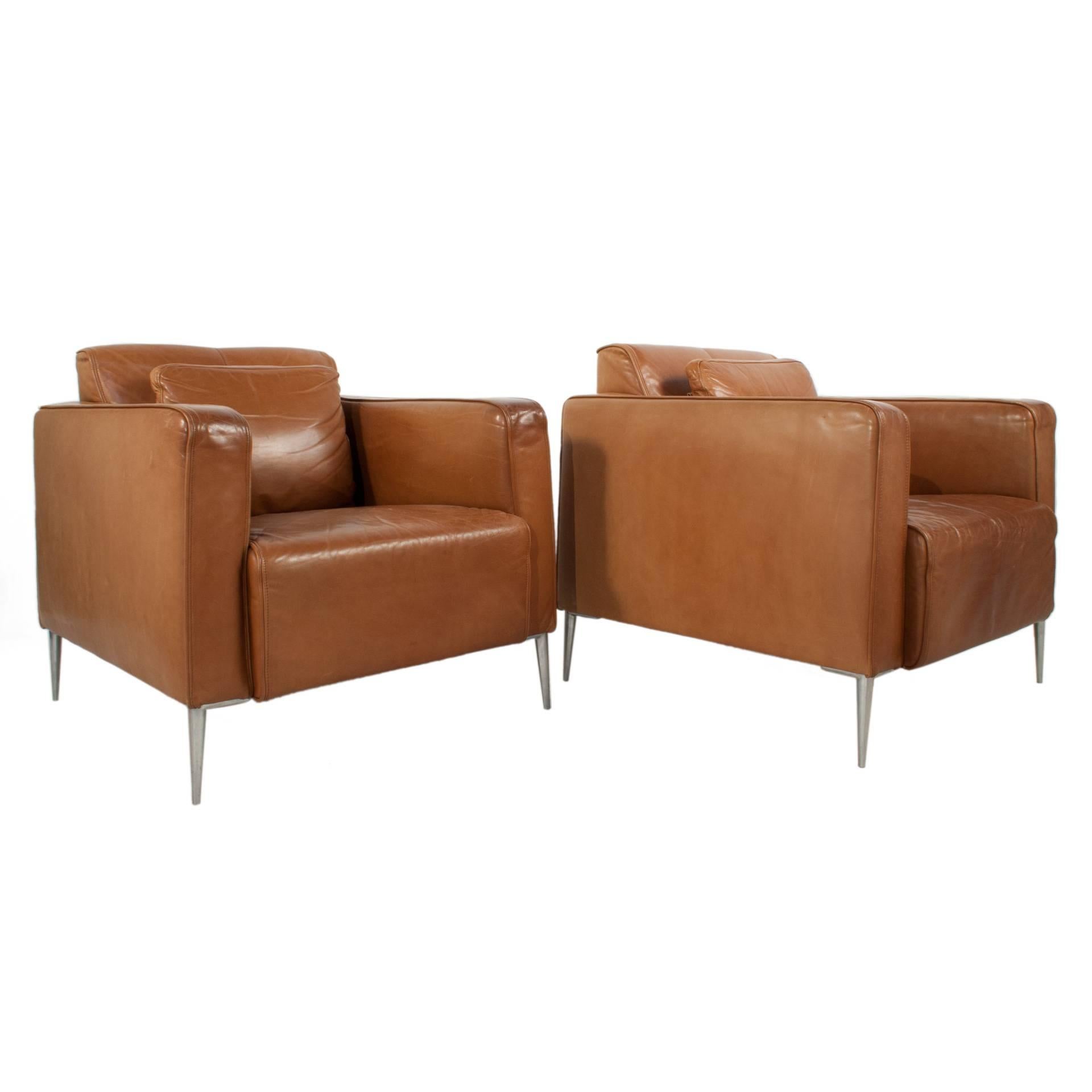 Pair of leather club chairs with steel legs.