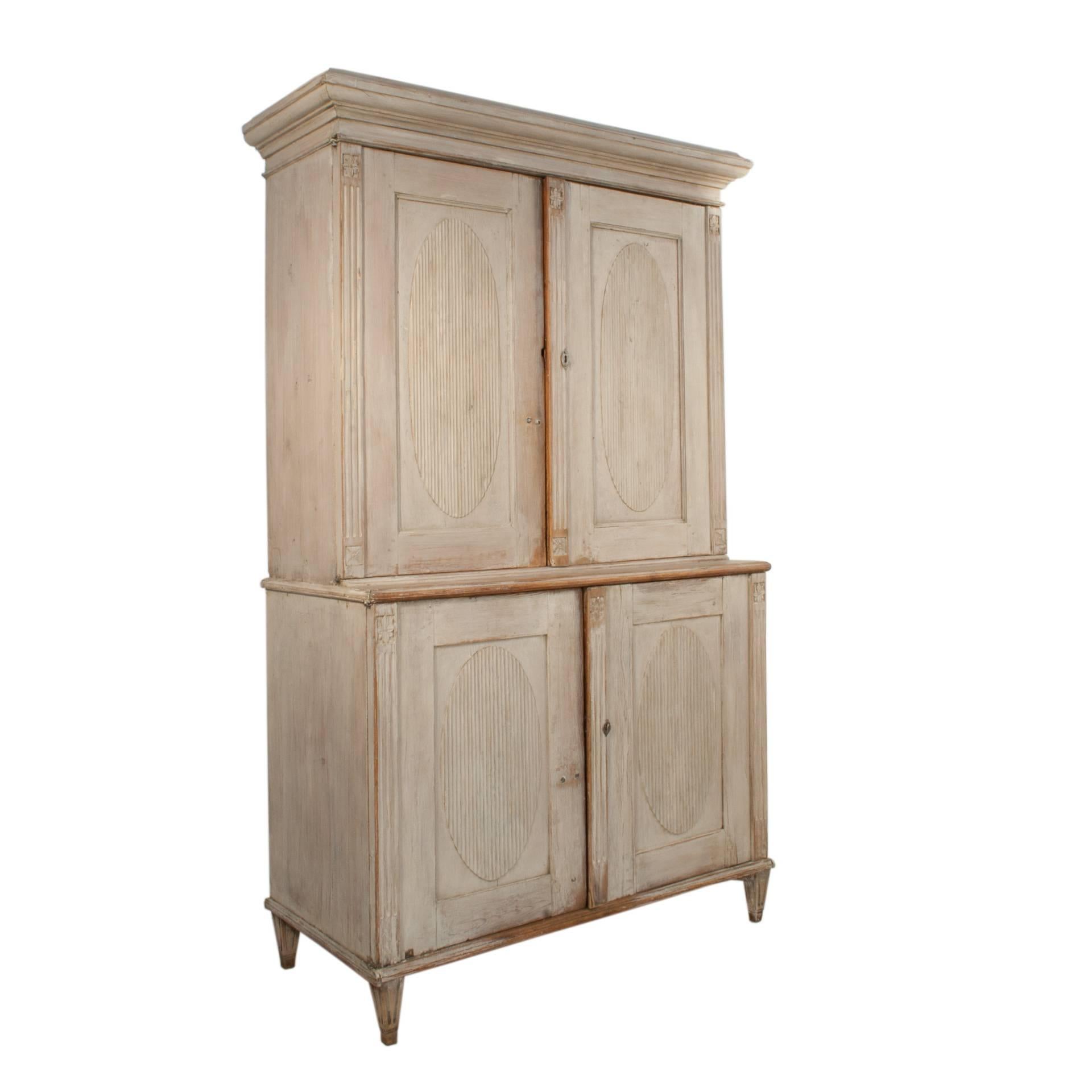 Gustavian cabinet with four doors in a worn pale grey patina.