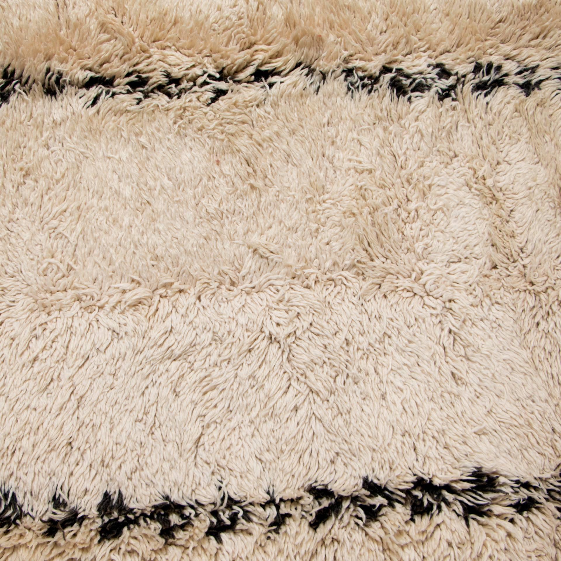 Vintage handwoven wool rug by the Beni Ourain tribe.