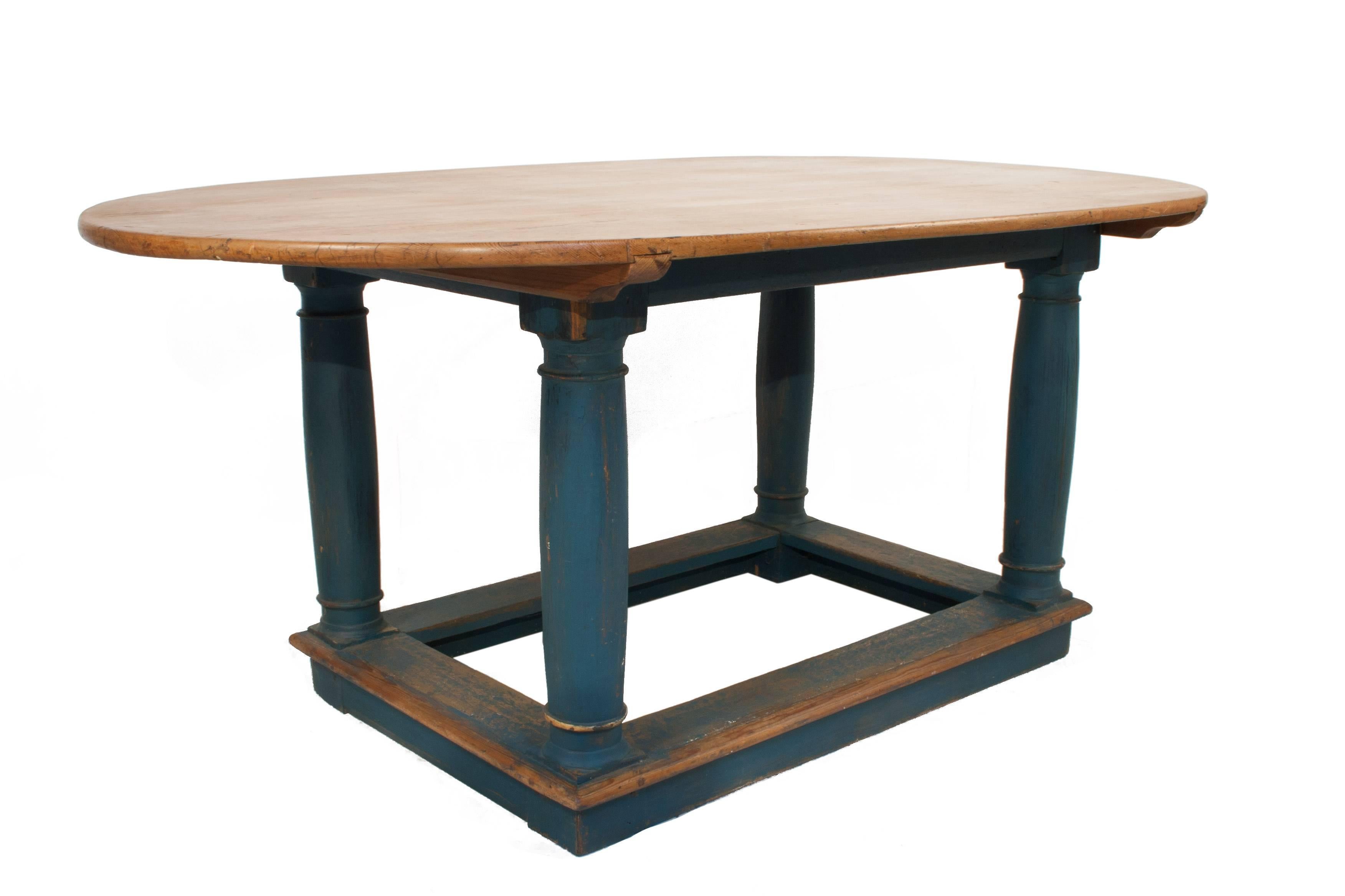 Baroque oval table with a worn blue patina on the base.