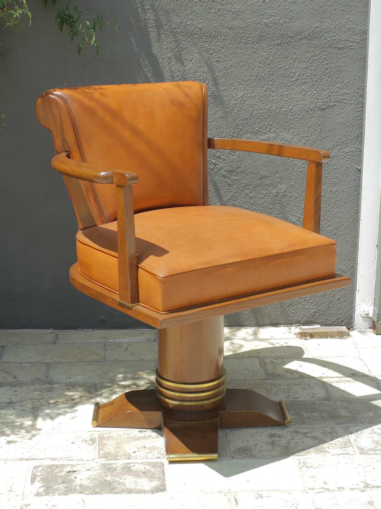 Exceptional and rare oak and brass swivel desk chair attributed to Jules Leleu, France, 1930.
Upholstered in patinated camel leather.
Refinished.
The quality of this piece is remarkable and finding a chair like this one is equally as rare from