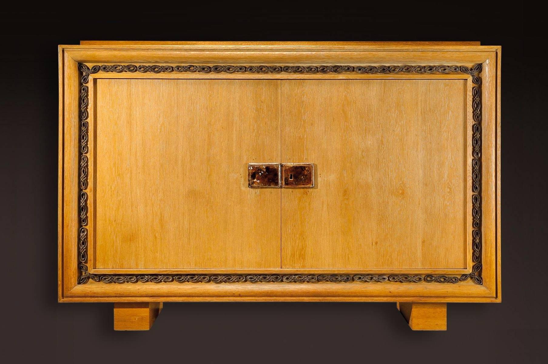 Attributed to Jacques Adnet (1900-1984) for " La Compagnie des Arts Français " & Maurice Savin (1894-1973)

Large two doors torn oak sideboard with glazed enameled ceramic plates enclosing key system section and gorgeous geometric