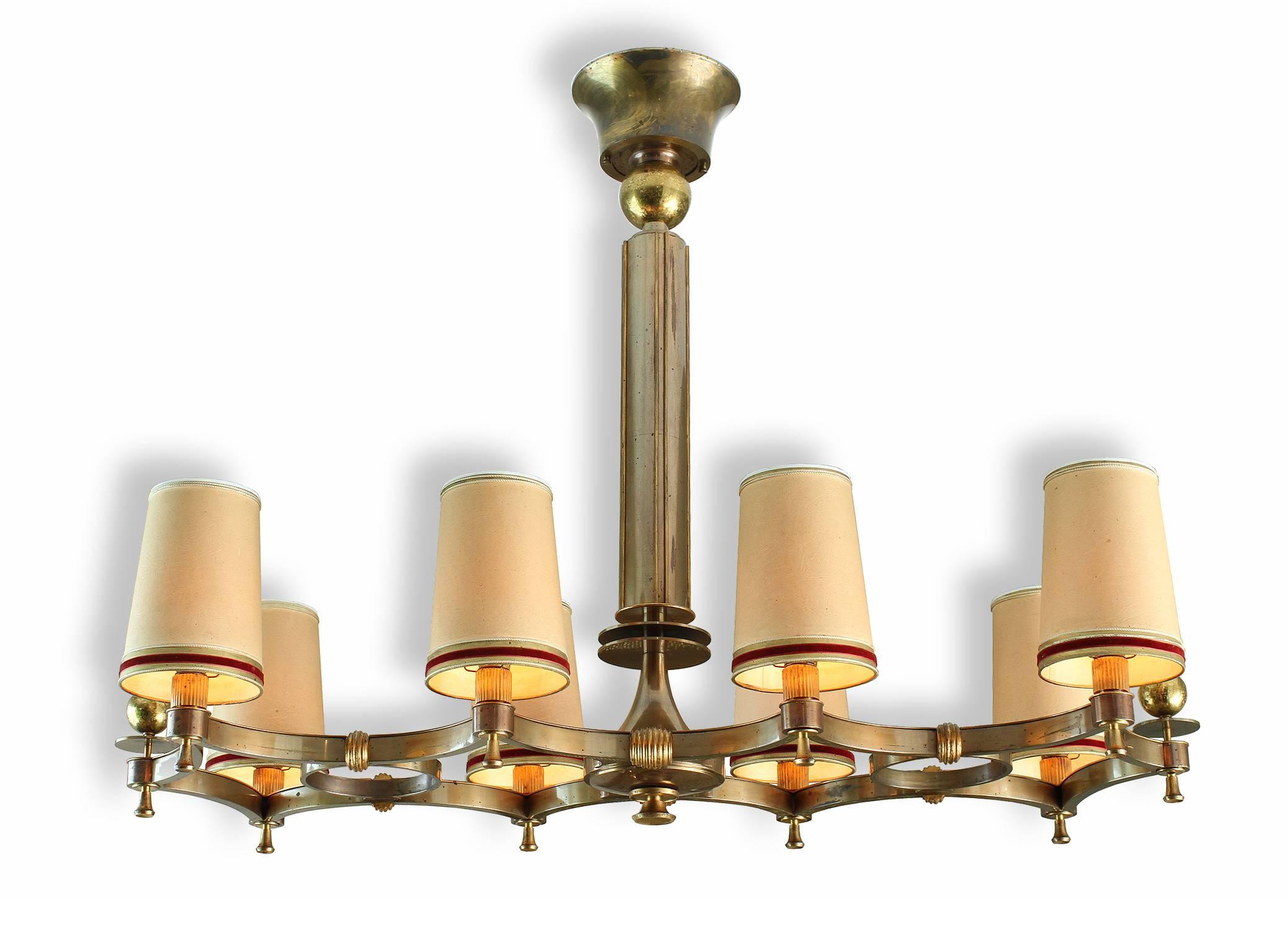 Maxime Old (1910-1991).

Exceptional and probably one-of-a-kind bronze eight-light chandelier with eight arms diffusing lights through original lampshades.

Two tones of brass and patinated bronze lightly oxidized, make this chandelier a perfect