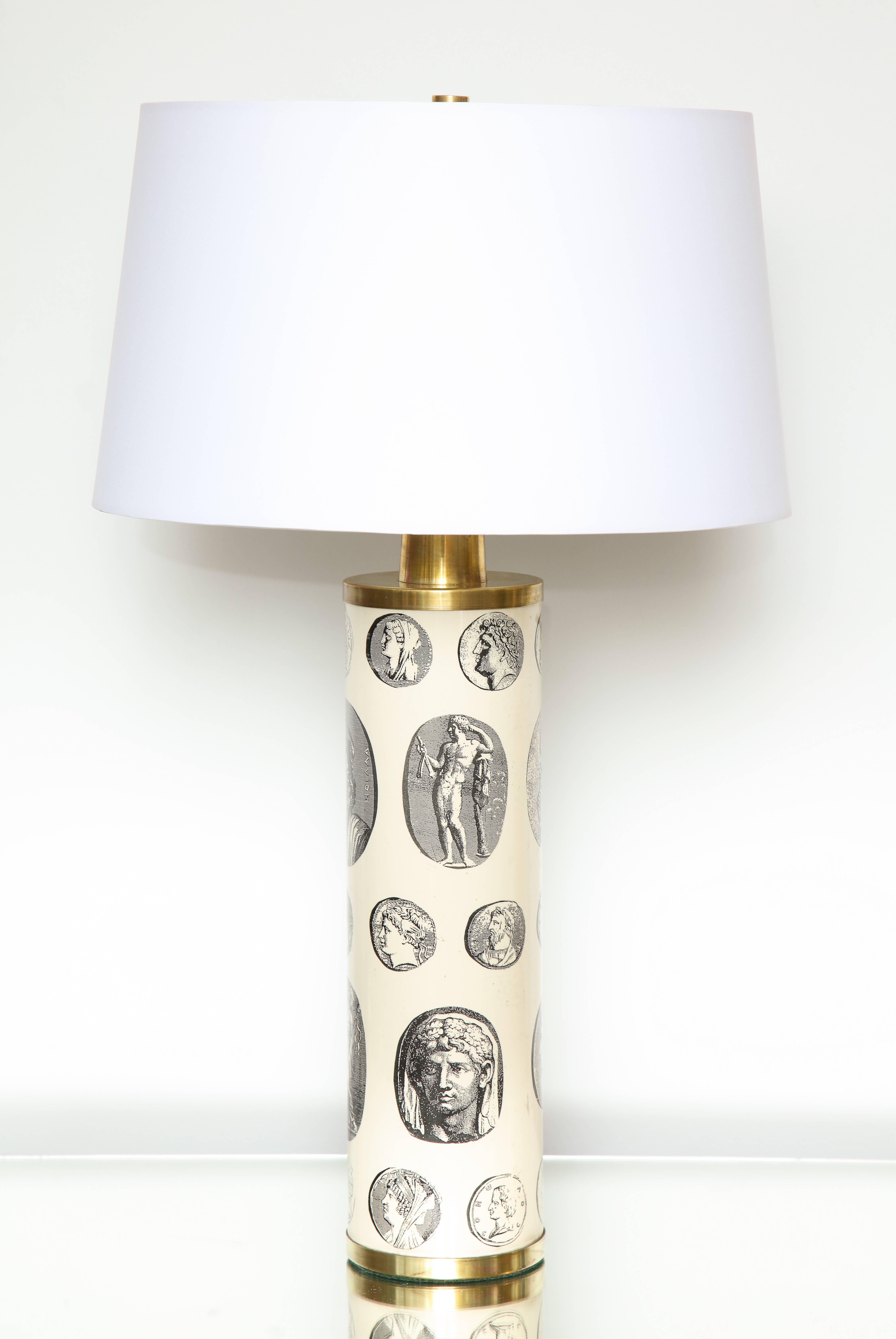 A fantastic pair of Fornasetti 'cameo' lamps in off white depicting Roman statuary and seals from 18th century illustrations. Shades included  however the shipping cost of shades is not  included 9