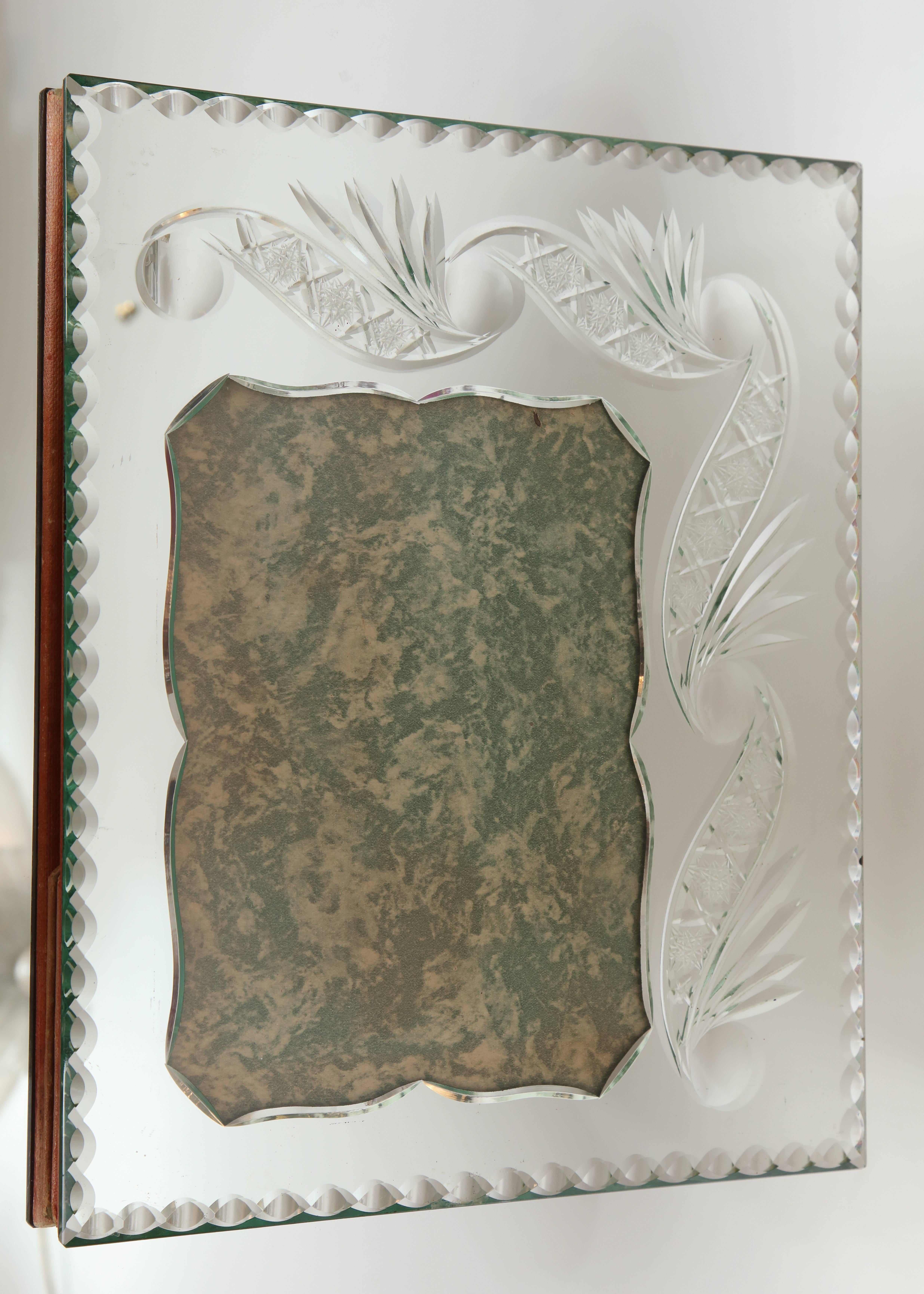 A fabulous French mirrored picture frame with deep wheel etched decoration and French bevelled edges. The frame can sit vertically or horizontally.