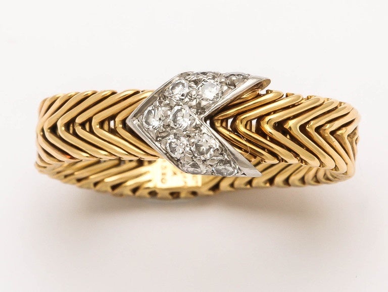 A design Classic by Paloma Picasso for Tiffany and Co. of a flexible 18-karat gold chevron band with a diamond encrusted arrow.
