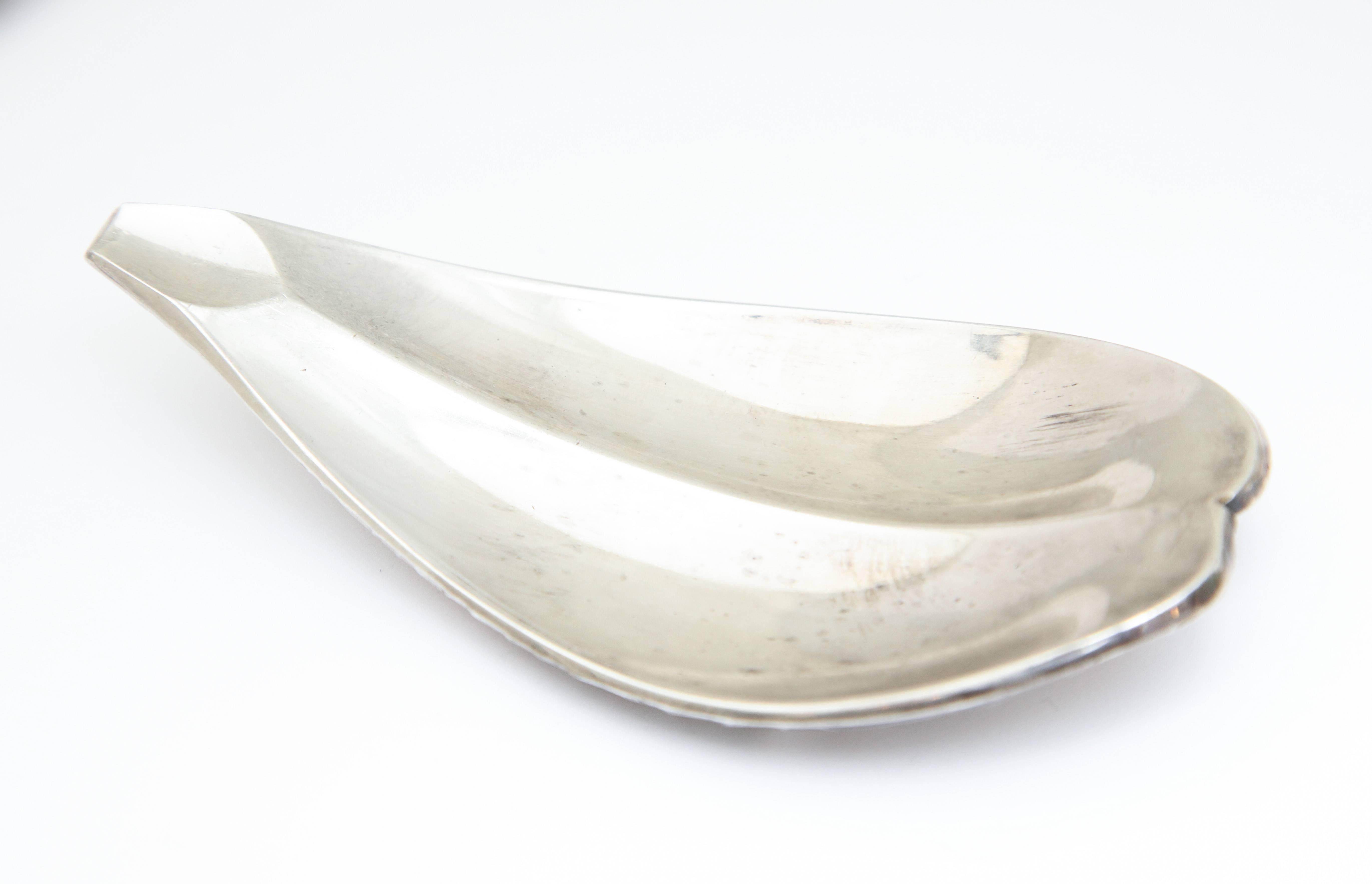 A wonderful hors d’oeuvres set with six individual scallop shaped dishes in fish form that sits on a great stand with a central dolphin holder. Made by Fleuron for Christofle. Signed on rim.