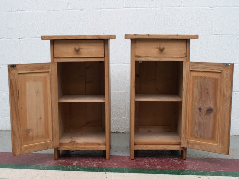 A charming pair of polished pine night stands in the usual one door one drawer configuration.  Single shelf to the interior.