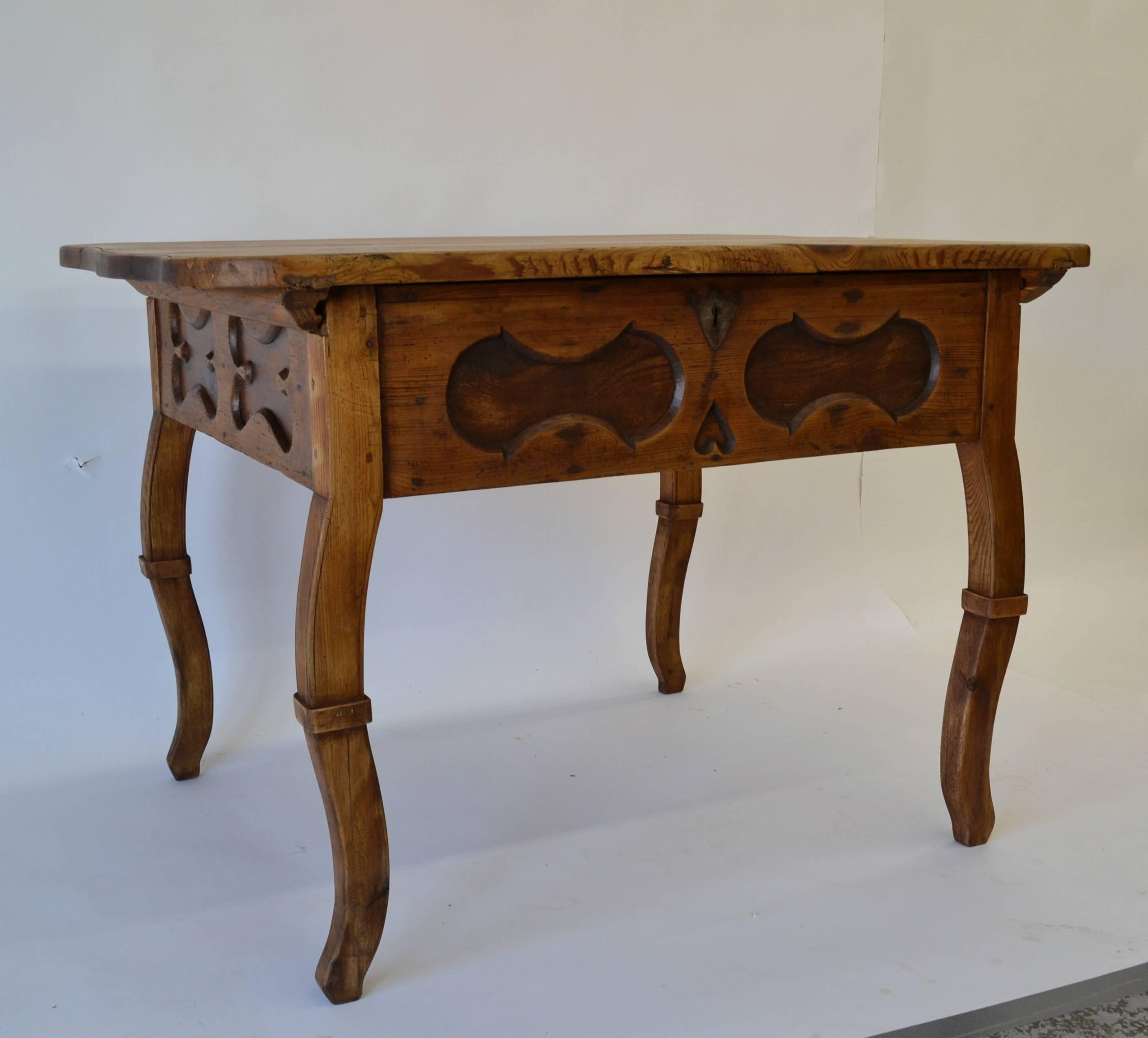 A most unusual find, this substantial pitch pine baroque-style centre table has a thick top, serpentine on all four sides with an incised band to the top edge. The top unlocks on its original lock (the key is a replacement) and slides backwards to