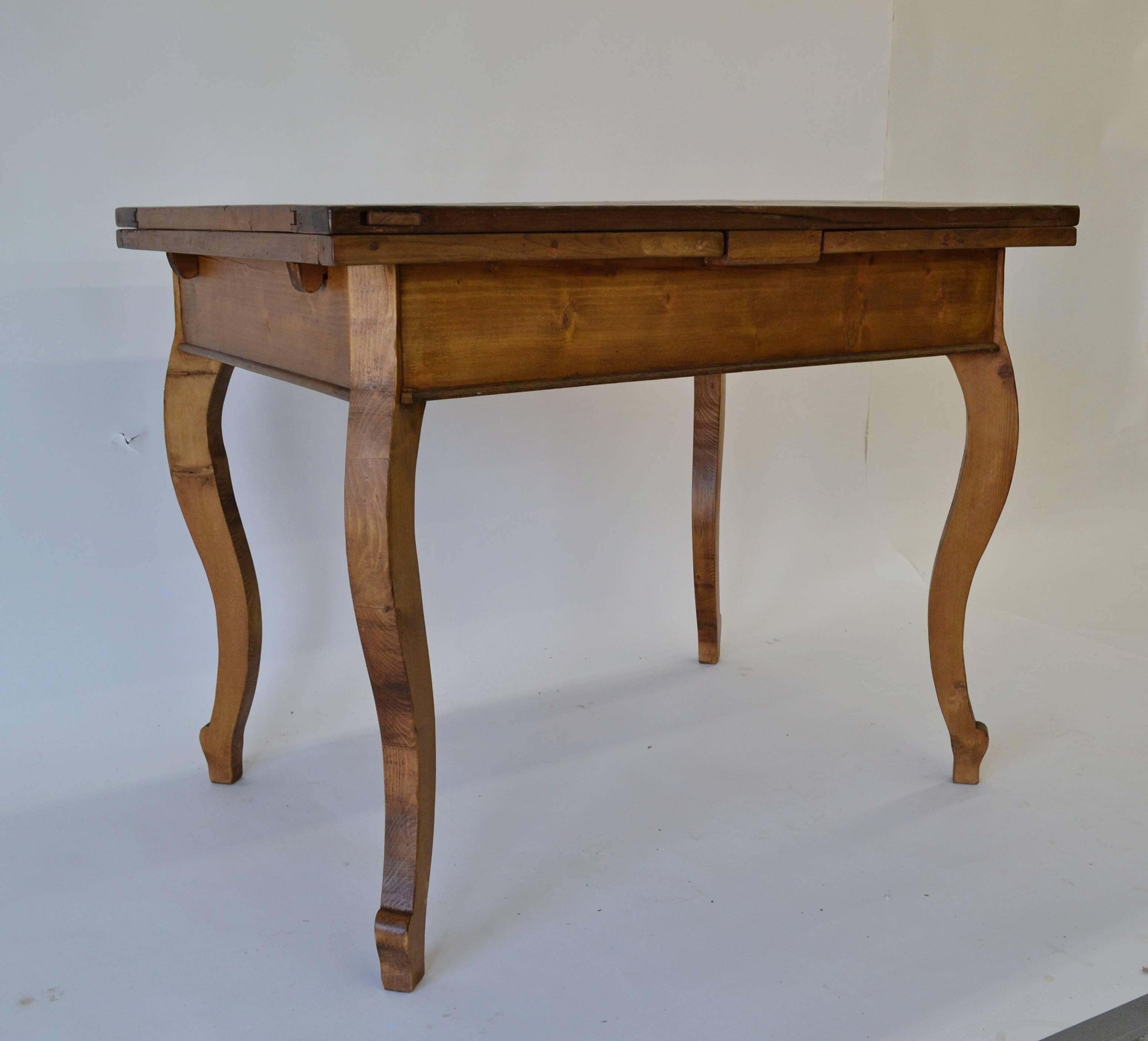 An unusual cabriole leg draw leaf table with a chestnut top of parquet design and pine leaves, bread boarded at the sides with chestnut. The 40” long top expands to 74” when the leaves are extended. The leaves are mounted on hardwood arms which