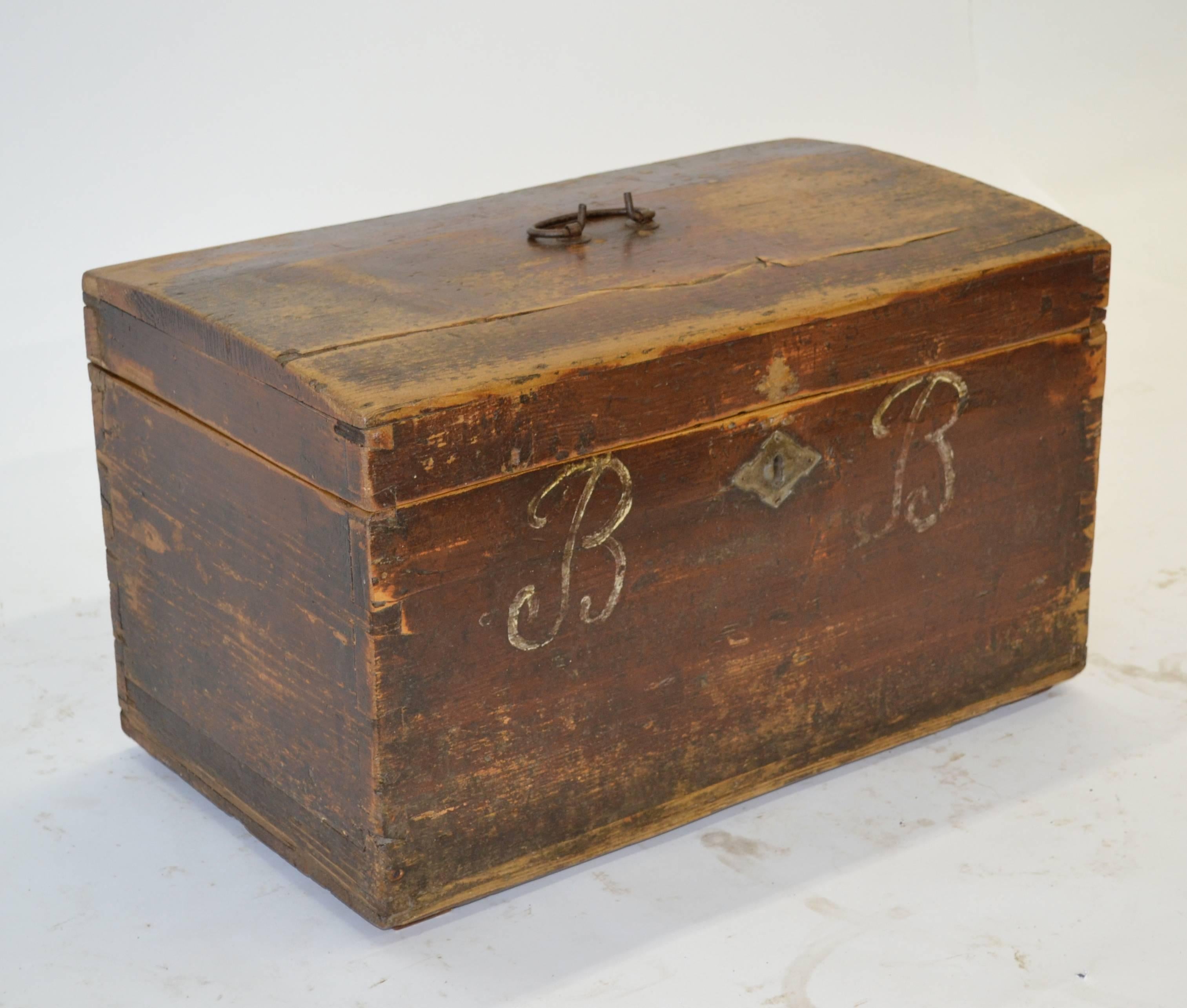 A World War II era pine dovetailed army box with wrought iron carrying handle and zinc escutcheon plate. This box has a slightly domed lid. In original, beautifully worn oxblood paint with the initials “BB” painted in white on the front.
 