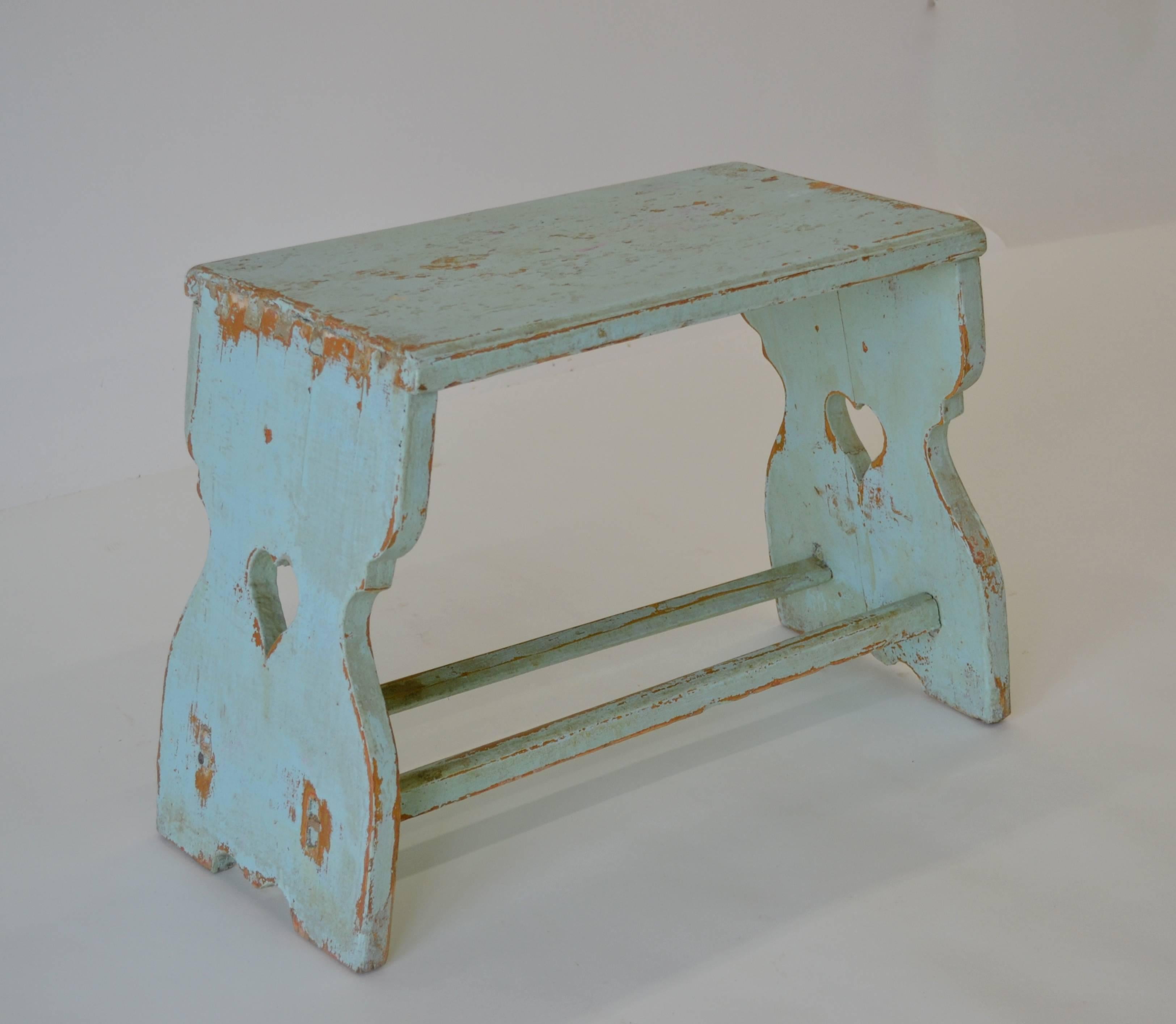 Another great looking pine footstool, taller than usual, with shapely splayed trestle ends dovetailed into the seat. The ends are joined with spokeshaved double stretchers and have a delightful heart shaped cut-out. In old light blue paint worn