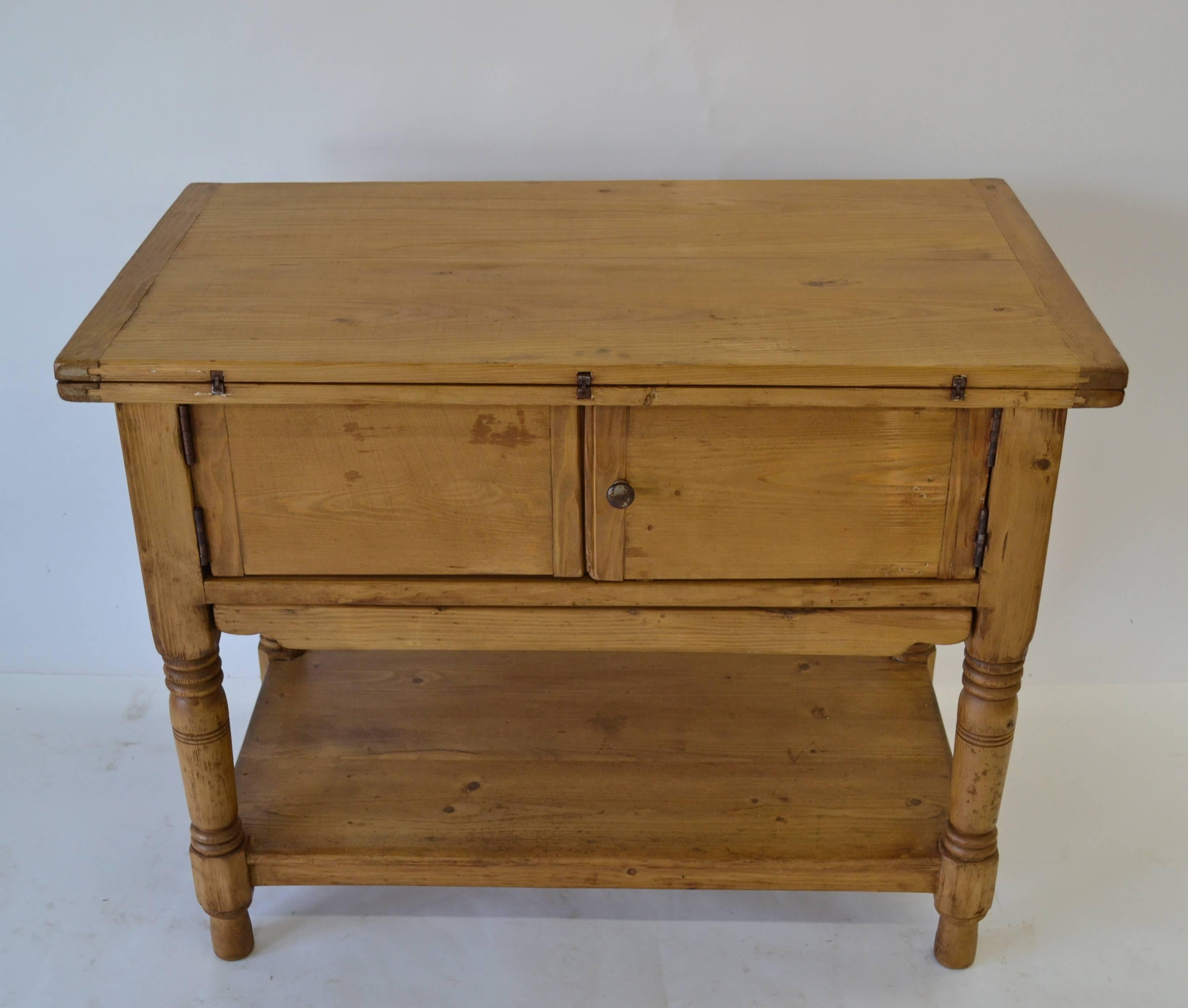 This is a remarkable little self-contained pine laundry table, the first we've seen quite like it, sadly missing its original zinc or enamel basins. Items for washing are gathered on the pull-out pine shelf beneath the cupboard doors. Then you lift