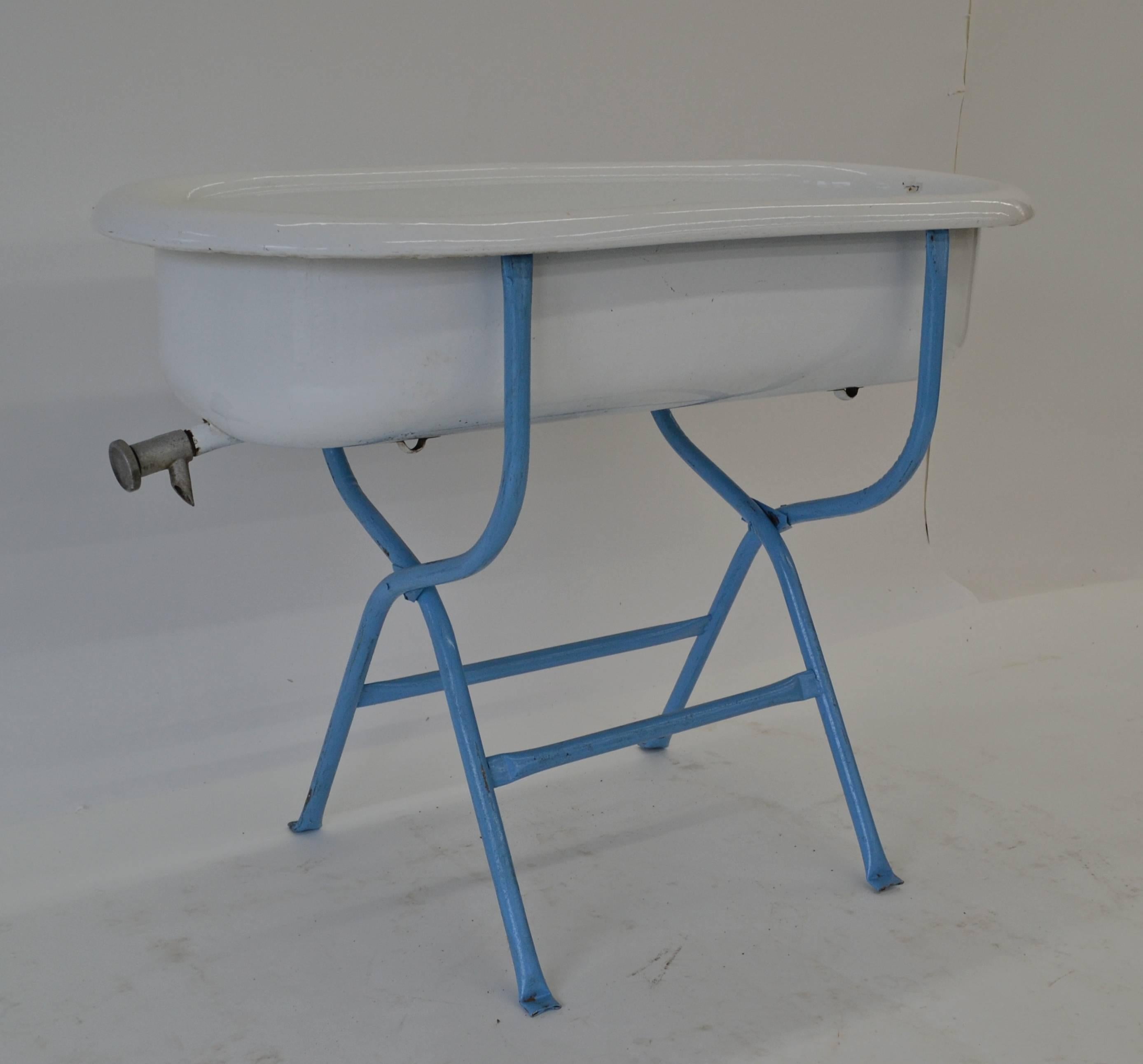 This vintage porcelain baby bath has a working drain tap and only small chips and scrapes to the surface. Mounted on a folding tubular frame, this bath has lots of landscaping uses is are perfect for filling with beer on ice at a cook-out. It can