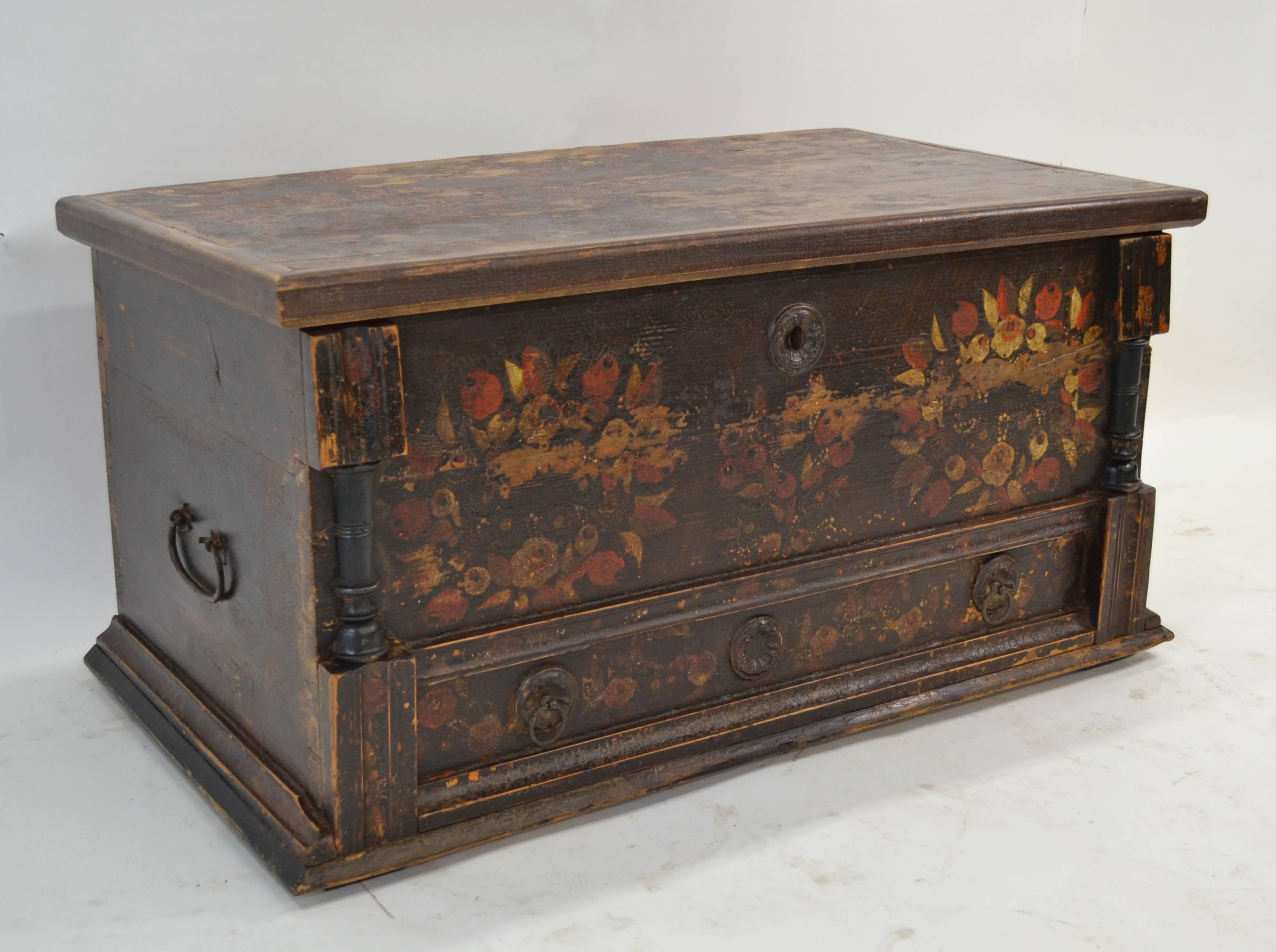 This painted faux mule chest, in the Baroque style, looks a little dark and gloomy at first sight but, caught in a favorable light, the more you look at it the more you see. The ground is a stylized grain paint in rich dark and light brown. Above