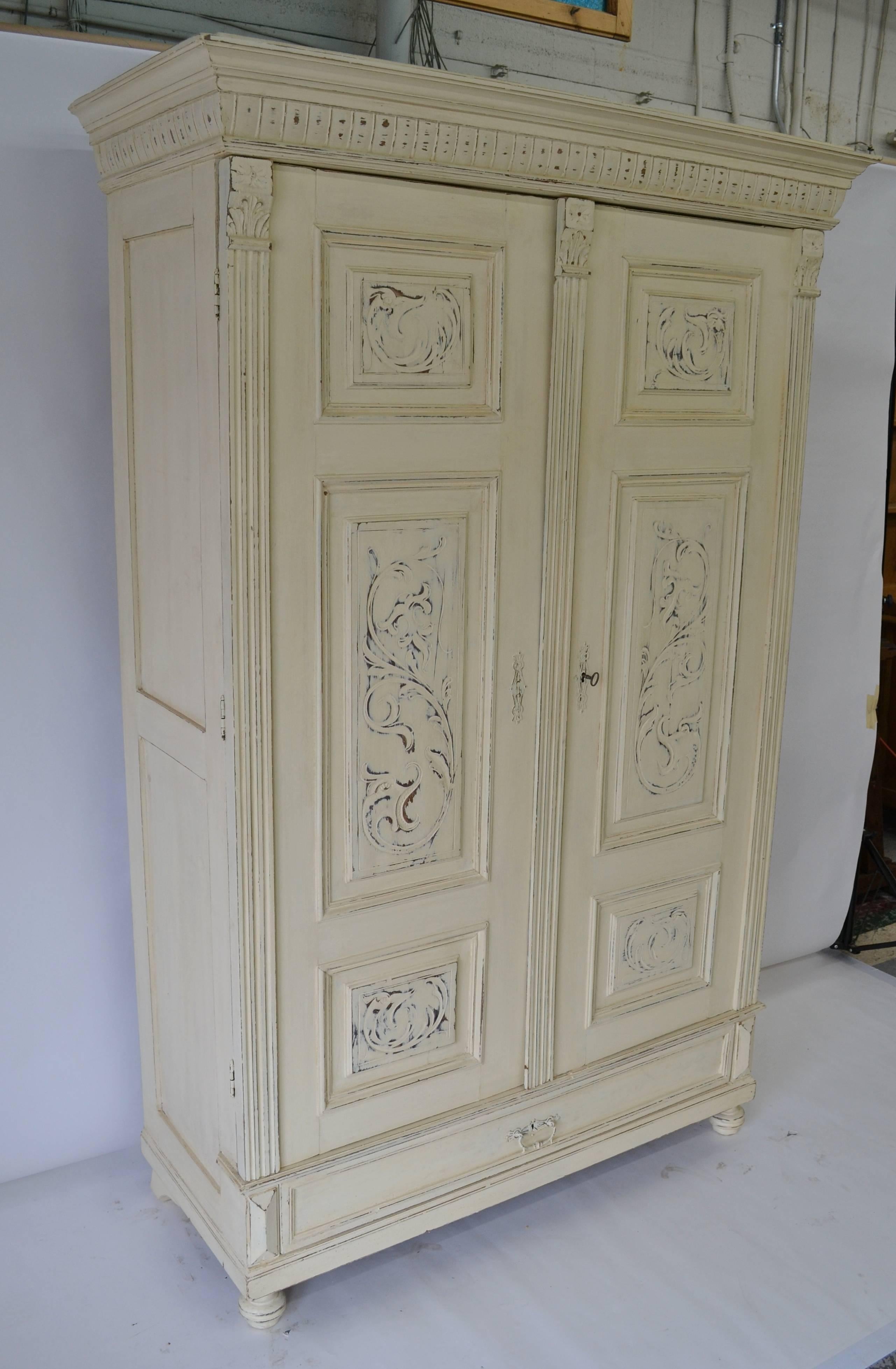 This handsome pine and oak two door armoire has three carved raised panels on each oak door, flanked and separated by applied fluting and acanthus leaf corbels. The doors open to a full 180 degrees, making this an ideal piece for housing a small TV.