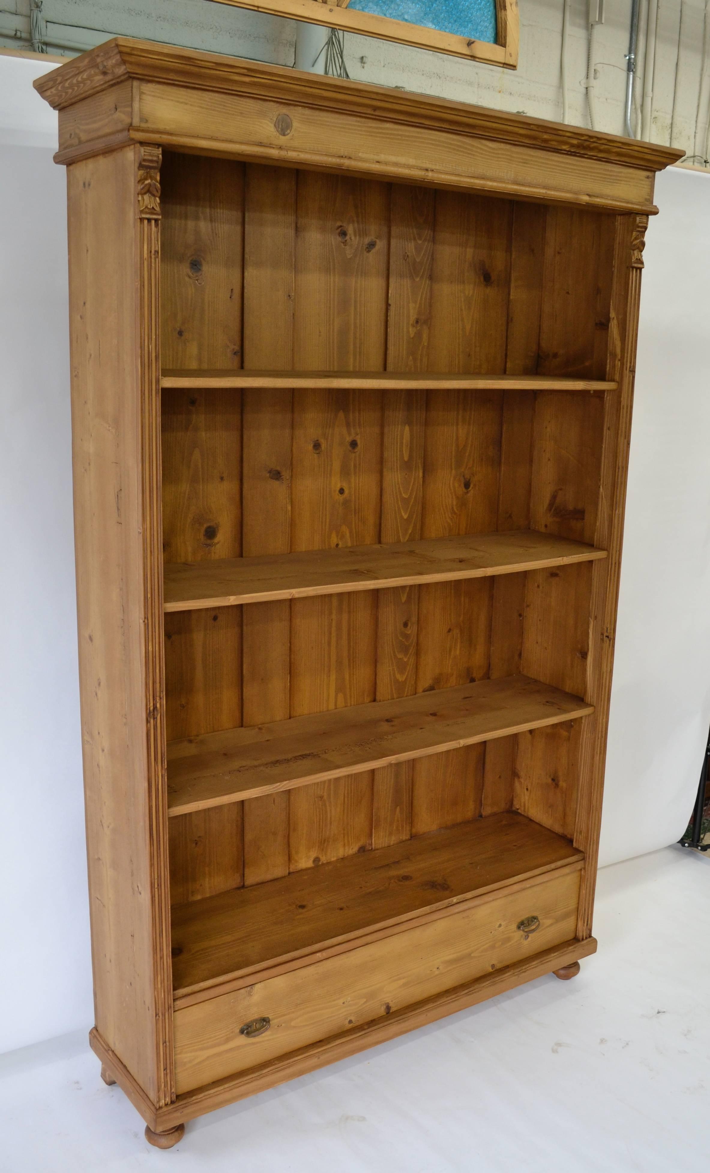 A vintage armoire that lost its doors provided the shell of this bookcase, with one side board removed to reduce the depth. All the old features and the deep rich color remain.