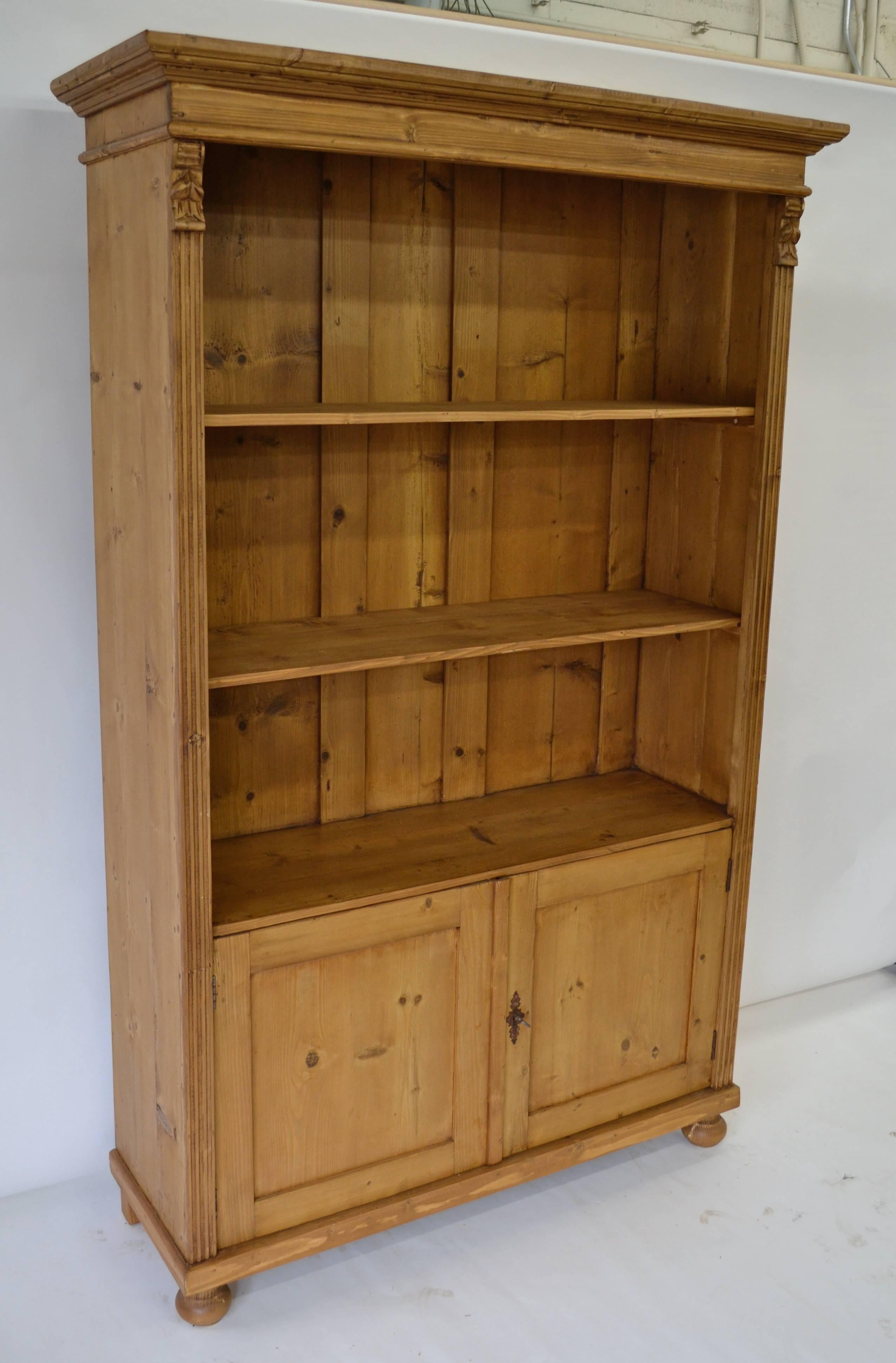 A vintage armoire with broken doors provided the shell of this bookcase, with one side board removed to reduce the depth and the doors rebuilt half-size. All the old features and the deep rich color remain.