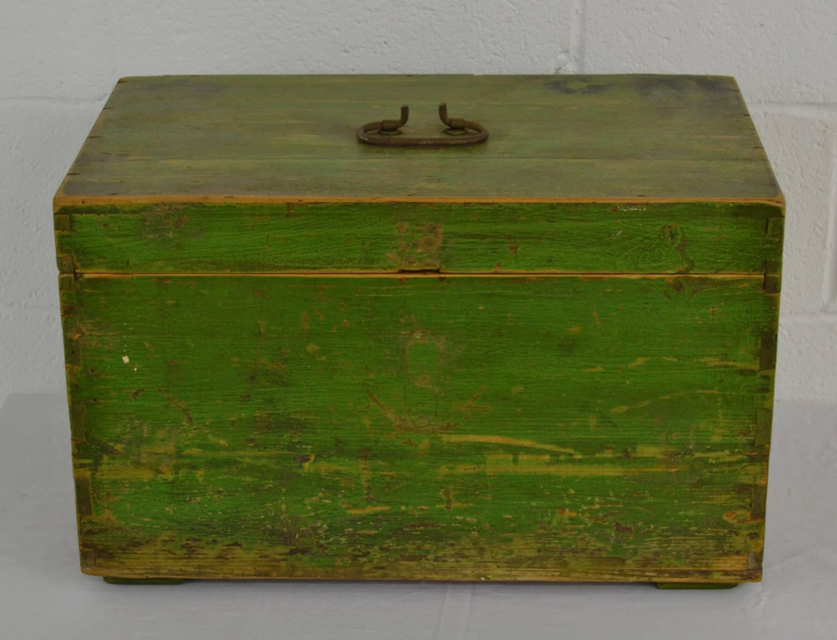 A vintage pine dovetailed army box with a wrought iron handle. In old green paint.