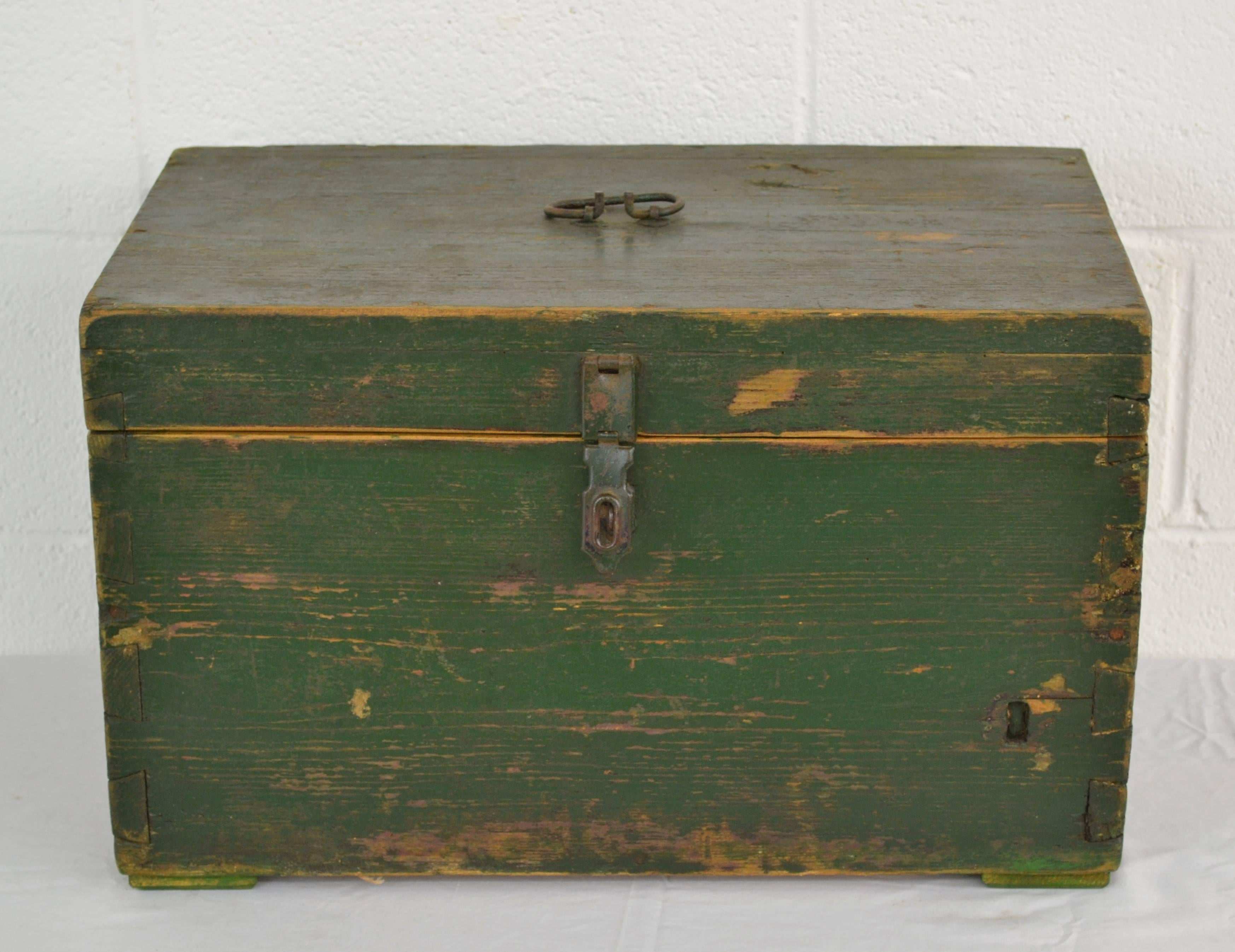 A vintage pine dovetailed army box with a wrought iron handle and working steel hasp. In old worn green paint.