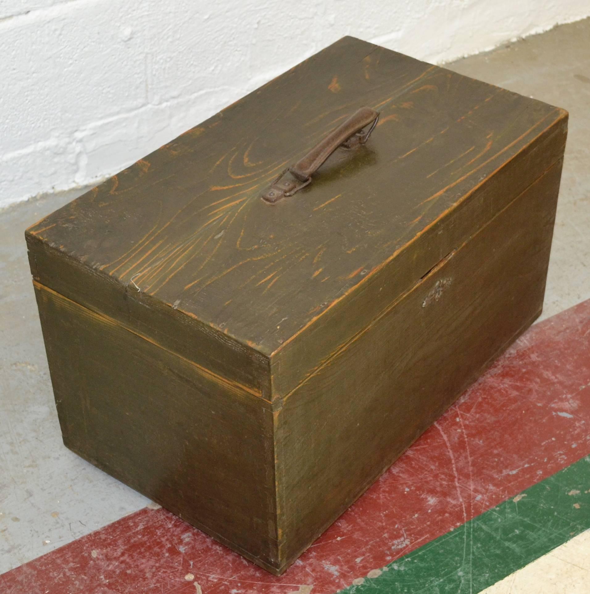 A handsome vintage pine army box with a leather handle, pressed zinc escutcheon, and a great patina. In old very dark green paint.