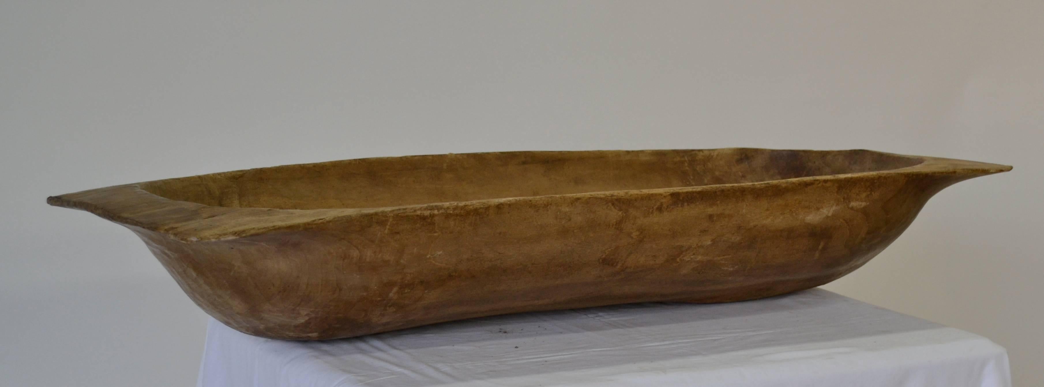 An attractive antique dough bowl or trog, beautifully hand-carved from a split log.  Great as a centerpiece or as a catch-all by the door to toss in scarves and gloves, or use for keeping kindling, logs, magazines by the fire.
This one is