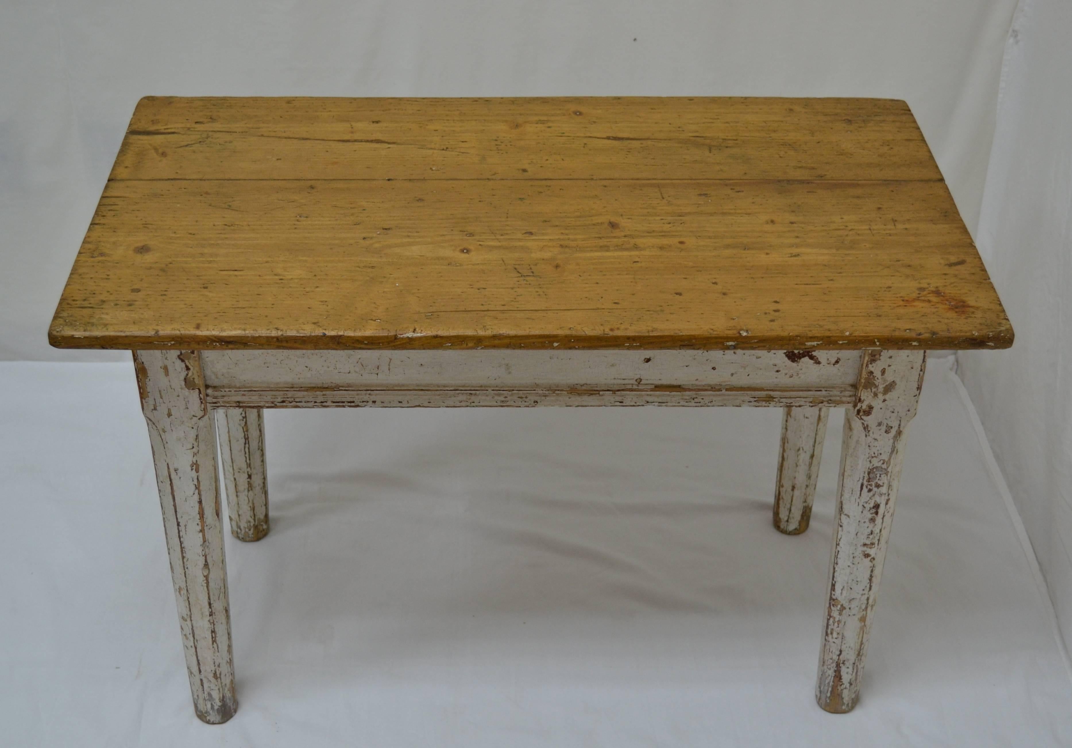 This is an attractive and very well made pine end table with a pretty two board top. The aprons feature horizontal applied reeding and are mortised into a most unusual leg. Beneath the square top block the leg is rounded and then chamfered into an