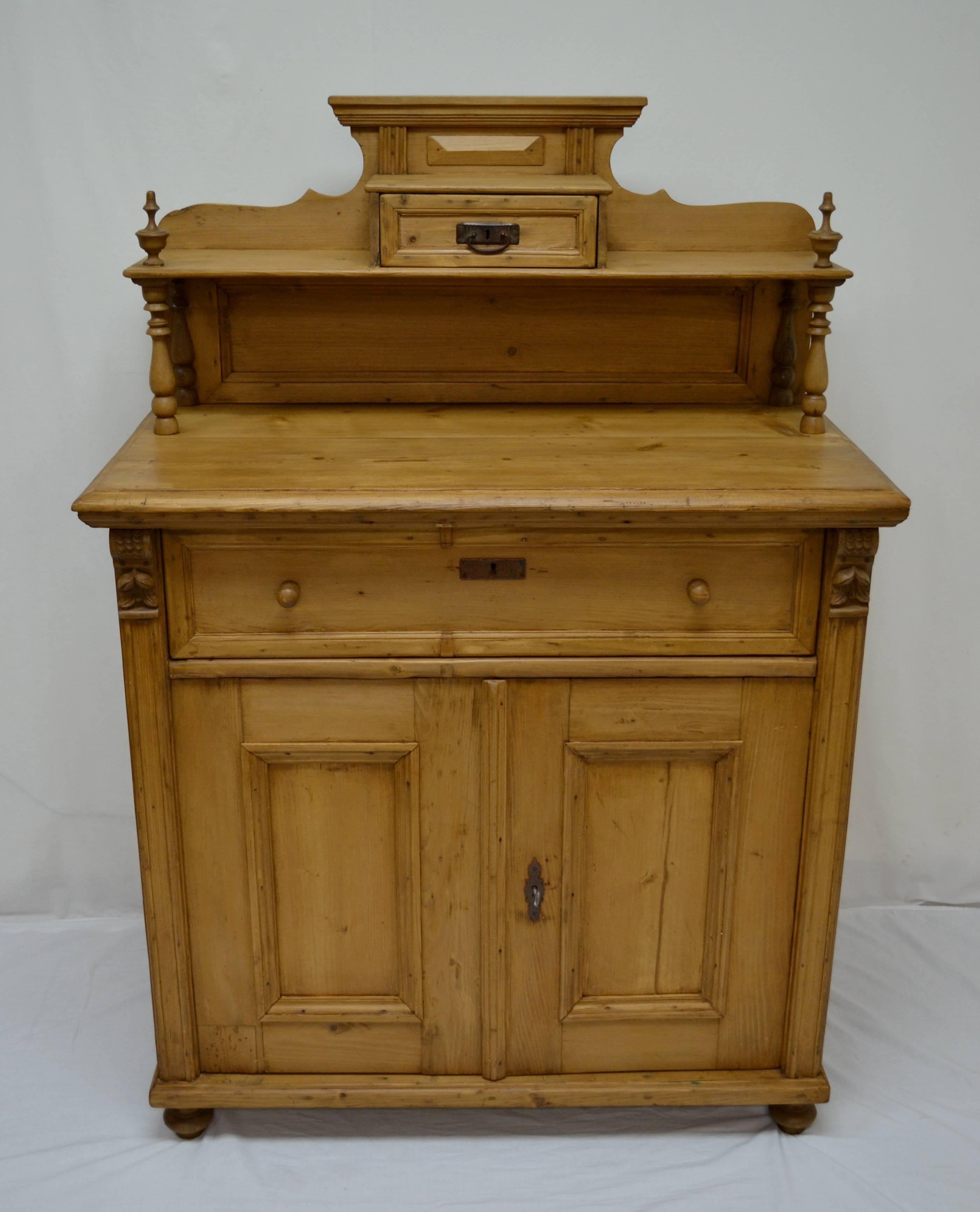 This is a most attractive pine chiffonier with beautiful proportions. The upper gallery features crown molding above a small hand-cut dovetailed drawer which sits on a shelf supported by a back panel and full turned hardwood balusters, topped with