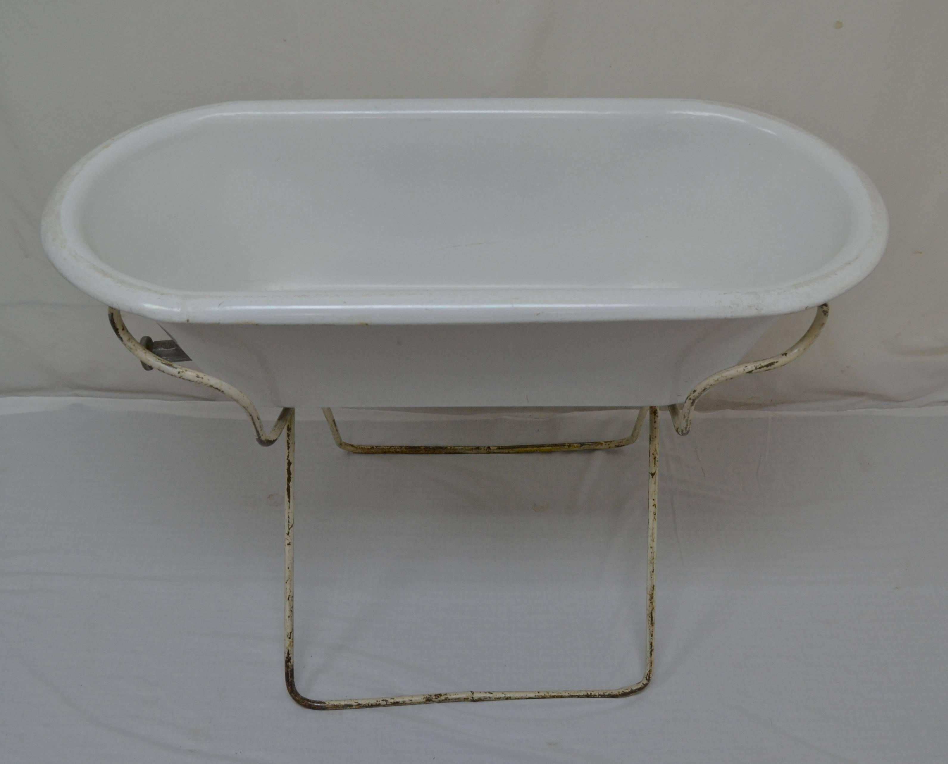 This is a charming porcelain enameled baby bath, deeper than usual by Kobanya of Hungary, mounted on an interesting original folding tubular steel stand. With summer approaching it would be great filled with bottles of beer or wine on ice, or