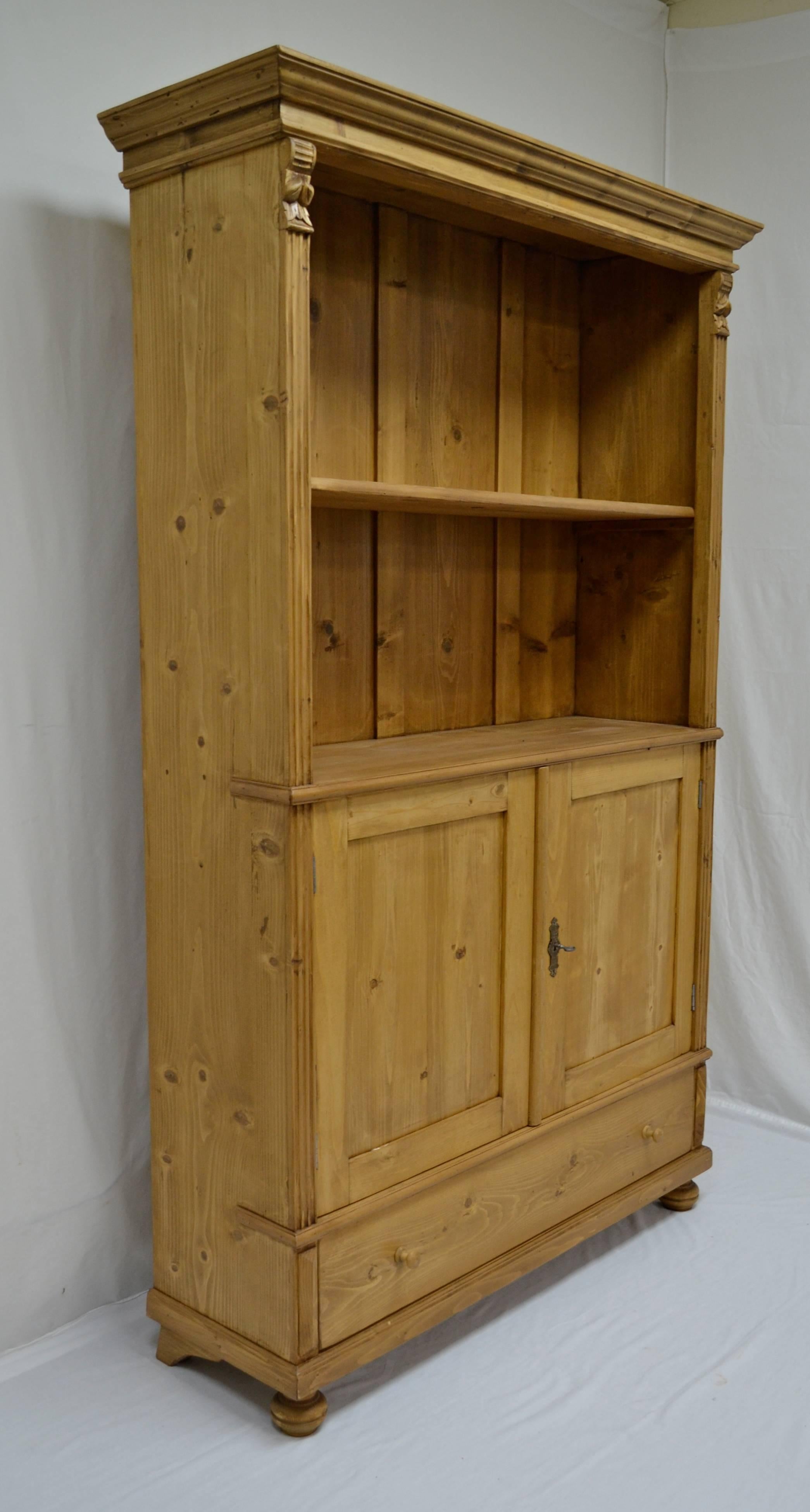 Antique pine bookcases are hard to find so the shell of this piece was provided by a vintage armoire. With one board width removed from the sides and the original backboards and crown molding retained; with the doors cut down, and the drawer reduced