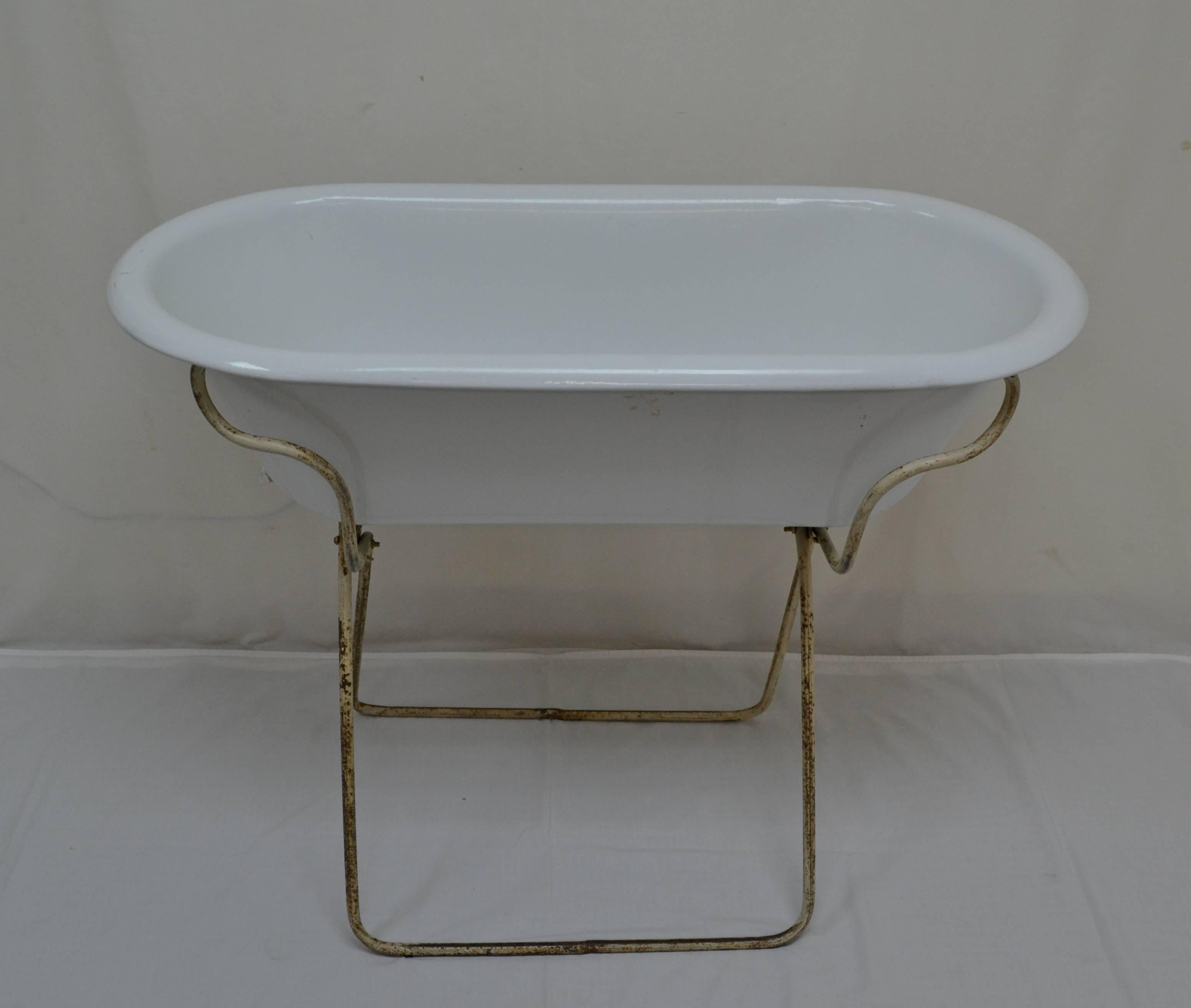 This is a charming, deeper than usual, porcelain enameled baby bath by Lampart of Hungary, mounted on an interesting original folding wrought iron Stand. With summer approaching it would be great filled with bottles of beer or wine on ice, or