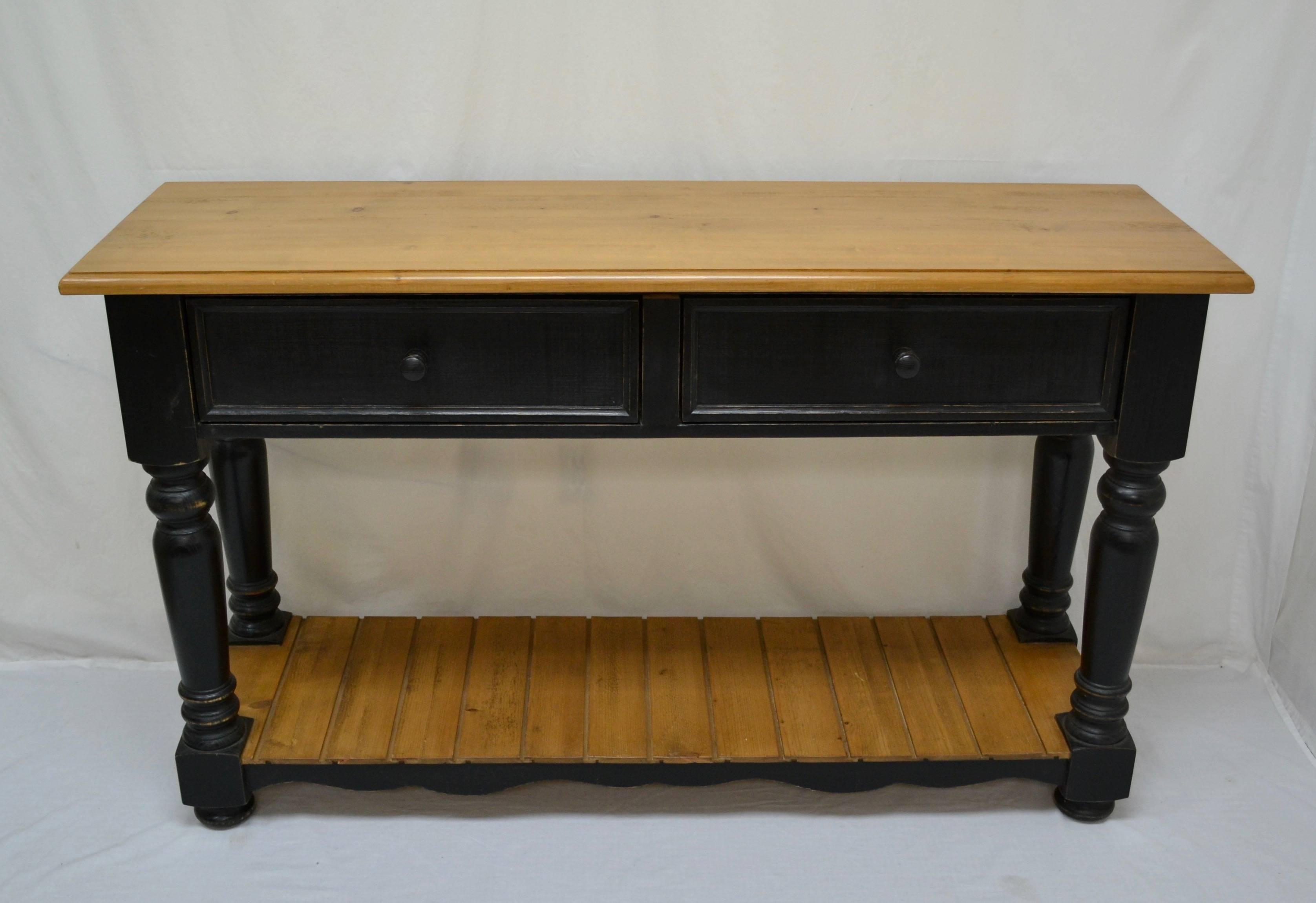 This is a handsome and distinguished English Jacobean style server with two deep dovetailed drawers set in a straight apron.  Four boldly turned legs and scalloped bottom rails support a sturdy tongue and groove potboard shelf.  This piece is great