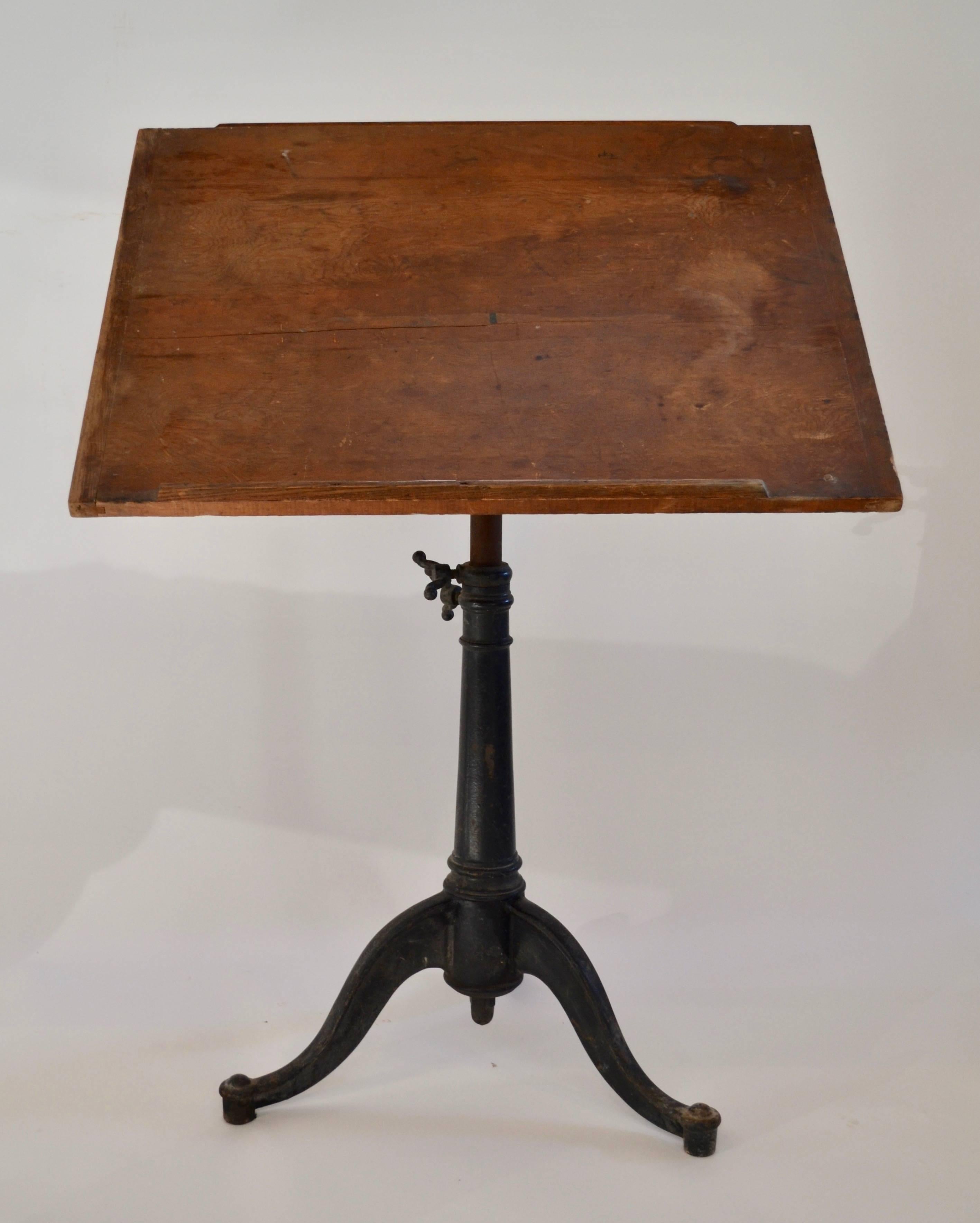 This drafting table has an original pine top and a very unusual drop down drafting instrument shelf, circa 1915
It adjusts from 30