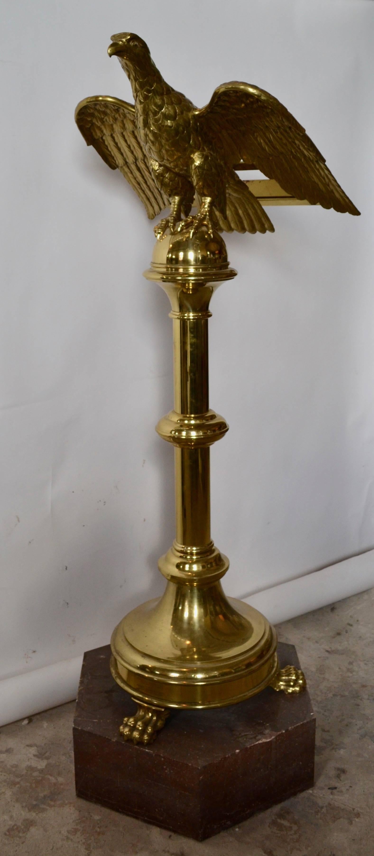 A spectacular polished and lacquered brass eagle lectern with turned columnar shaft terminating in paw feet. Brass works surmounted on Tennessee marble hexagonal base. The lectern is inscribed 