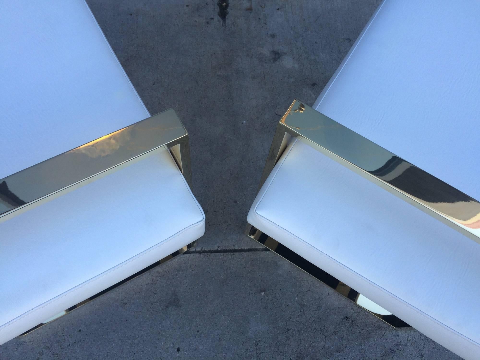 Pair of solid polished brass benches designed and manufactured by Charles Hollis Jones in the 1970s.

The frames of the benches are made in solid brass, they are upholstered in white Naugahyde but they are also available in other finishes such as