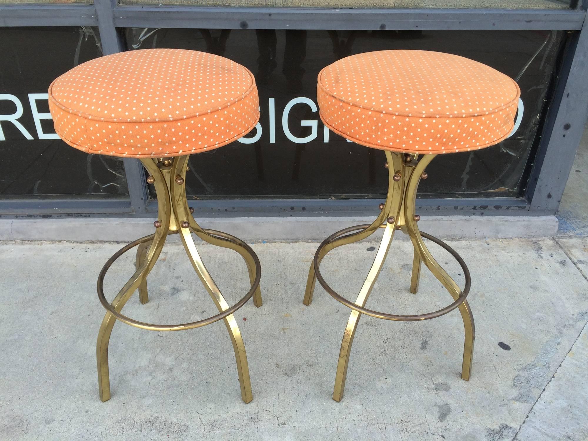 Rare pair of brass bar stools with swivel mechanism designed and manufactured by Charles Hollis Jones in the early 1960s.

The stools have great lines and are very comfortable, the swivel mechanism is smooth and works perfectly, the brass has a