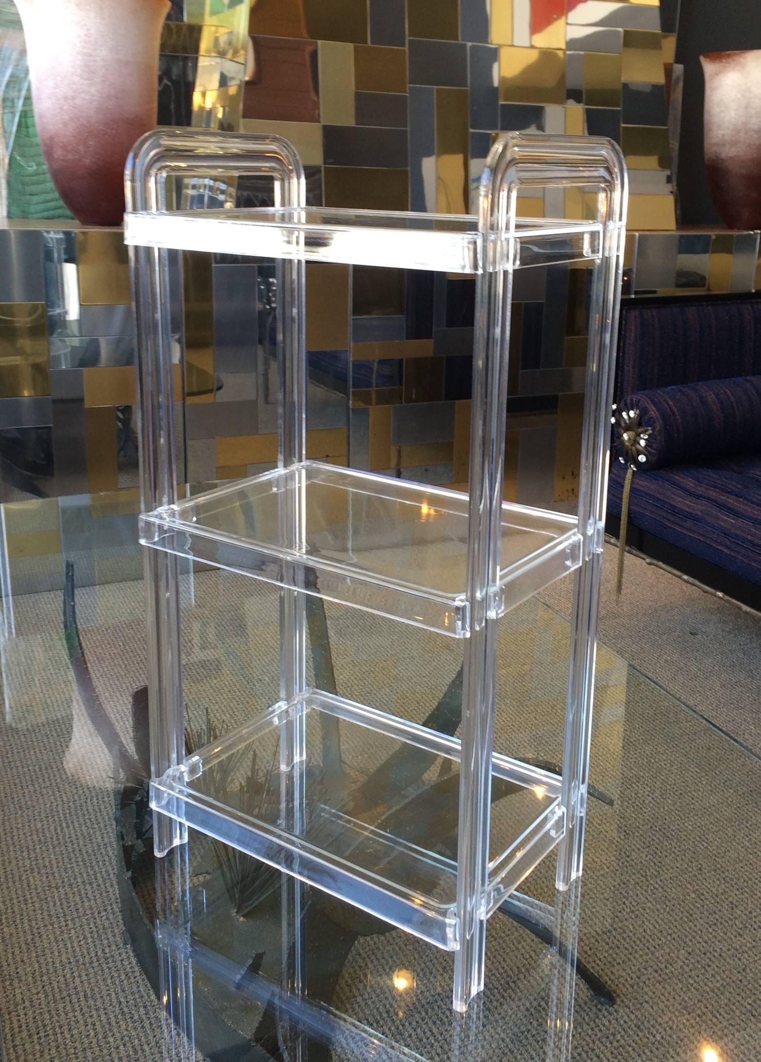Beautiful three-tier Lucite vanity shelving unit with removable shelves.
The piece is in very good original condition and light in weight so that it can be moved easily.

Measurements:
28