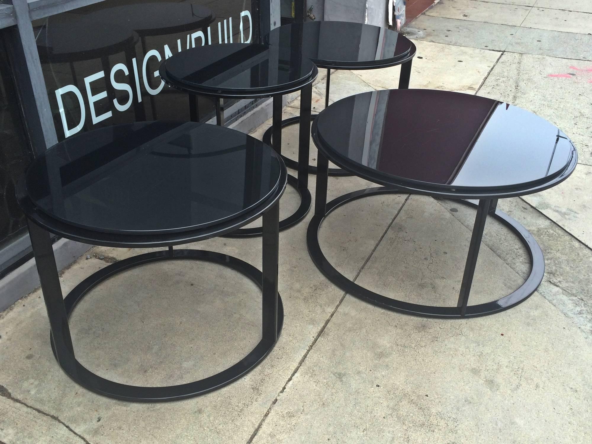 Beautiful set of four tables (one coffee table, two side tables and an additional side table) in black tubular steel and reverse painted black glass tops designed by Antonio Citterio and manufactured by B&B Italia.

These tables can be used